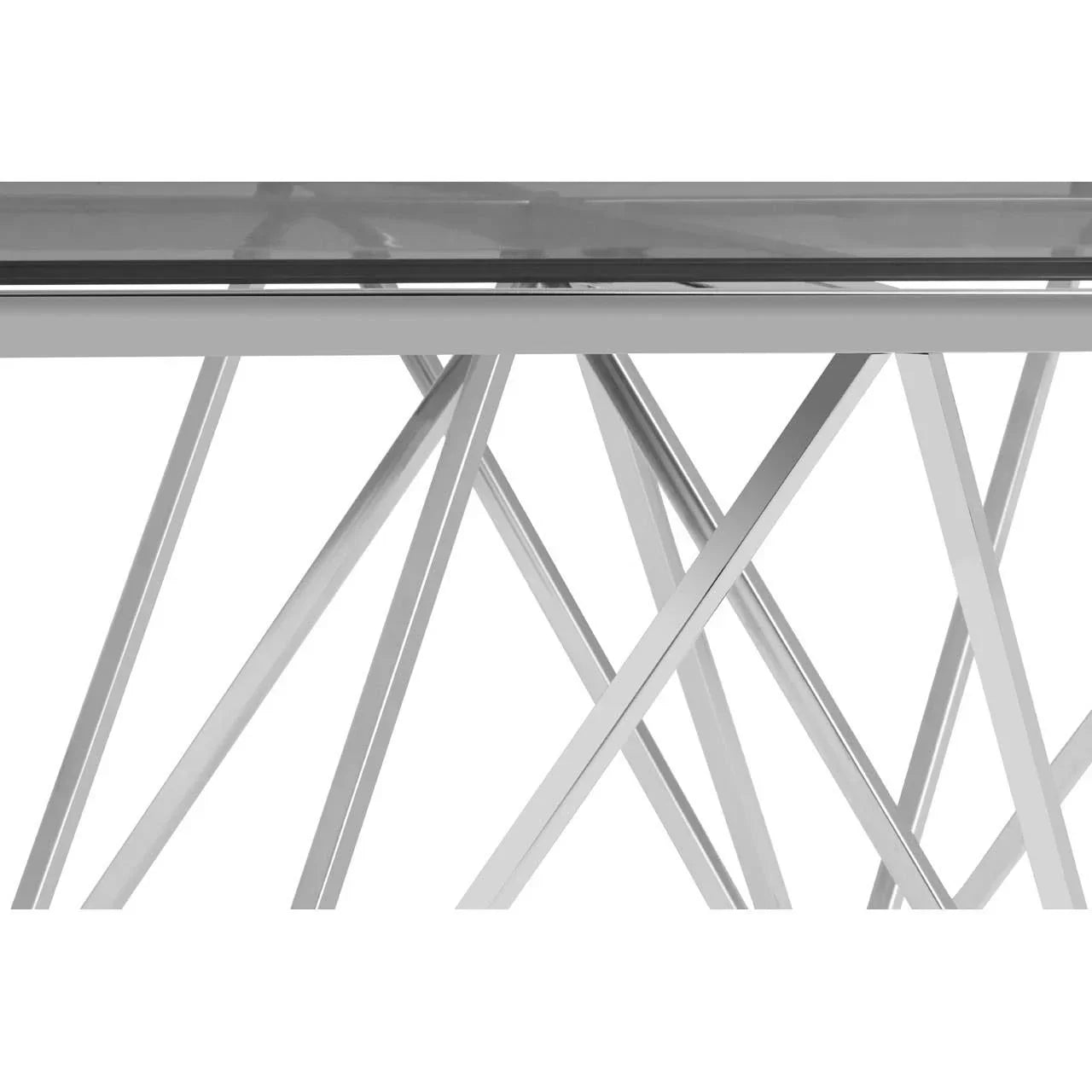 Glass top dining table with chrome crossed metal legs, close-up of base detail