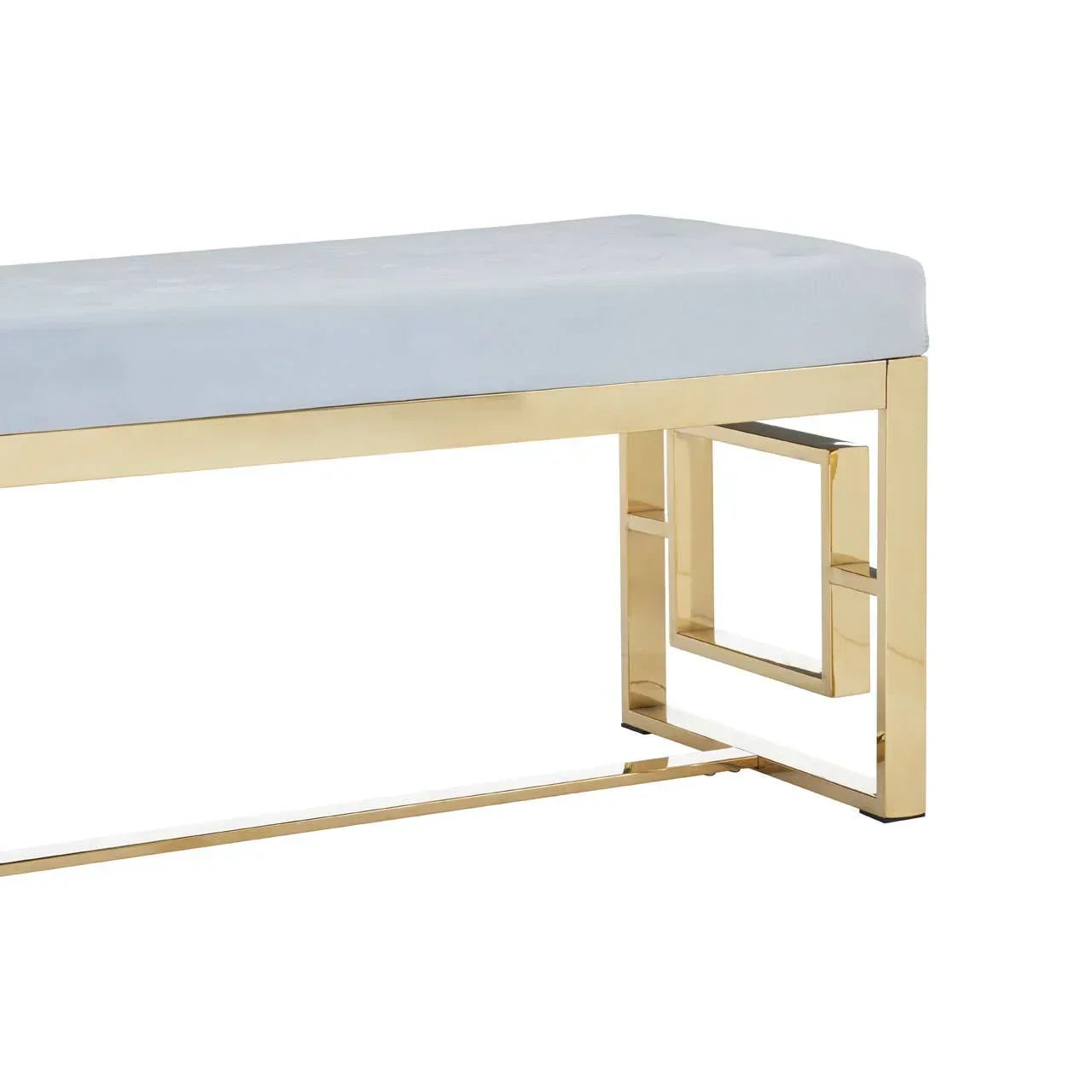 Upholstered bench with gold metal geometric legs and light grey cushioned seat