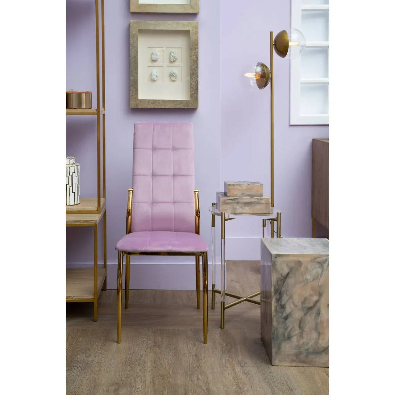 Pink velvet dining chair with gold legs positioned in a modern living room setting