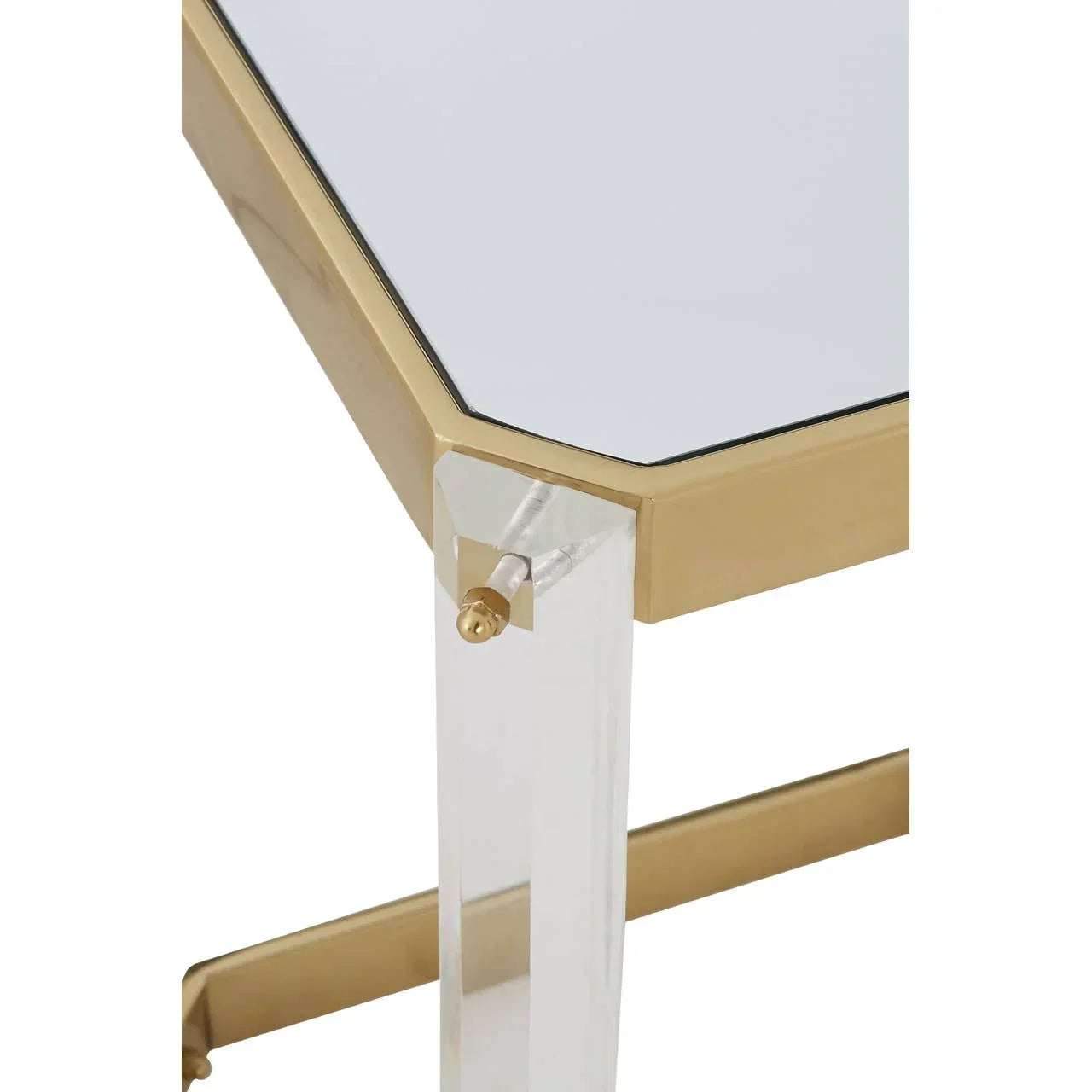 Glass side table with gold trim and clear acrylic leg, close-up of corner detail