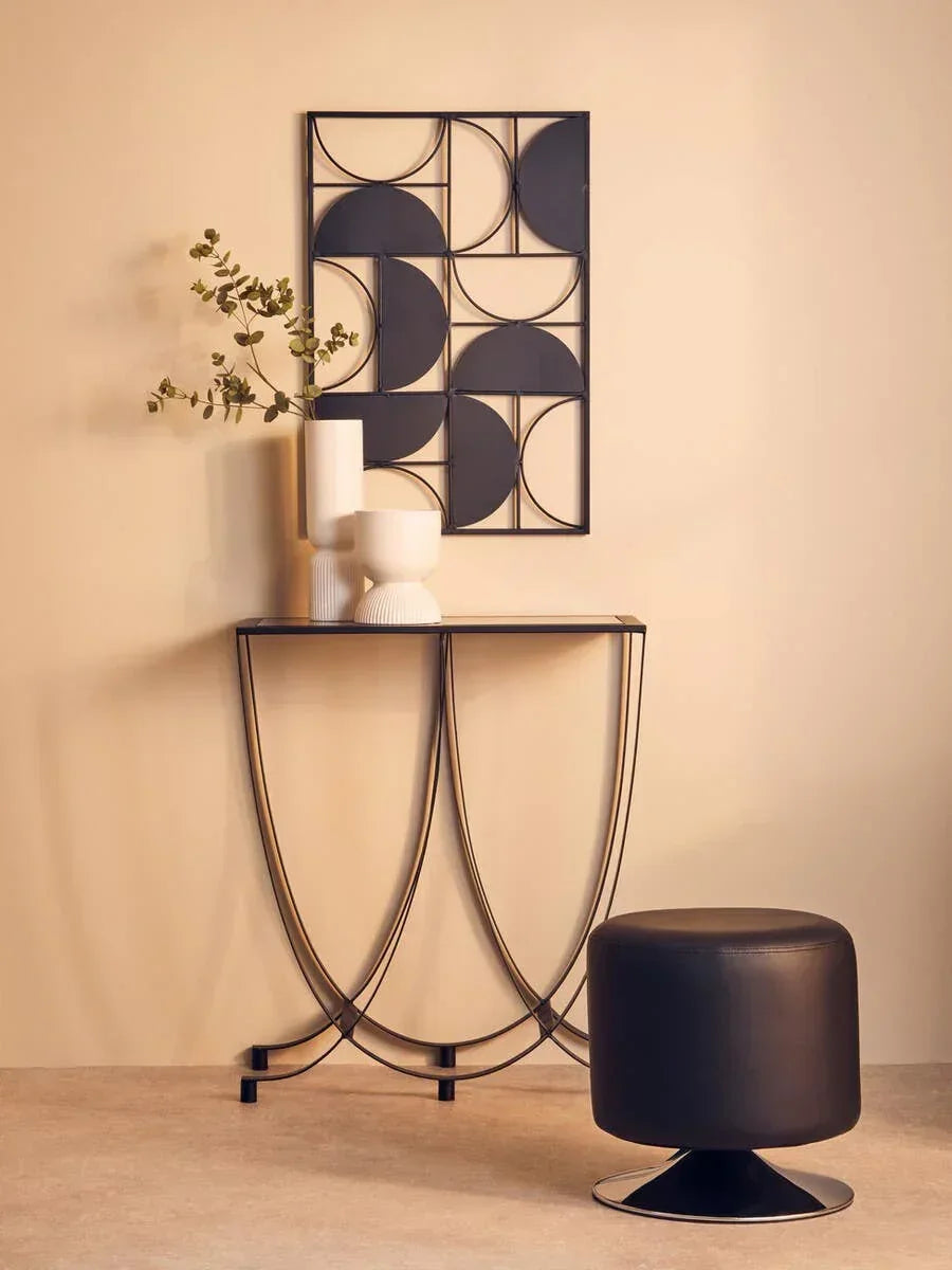 Black metal console table with white ceramic vases, black stool, geometric wall art