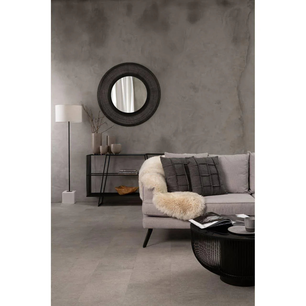 Modern grey sofa with black accent pillows and throw in contemporary living room setting