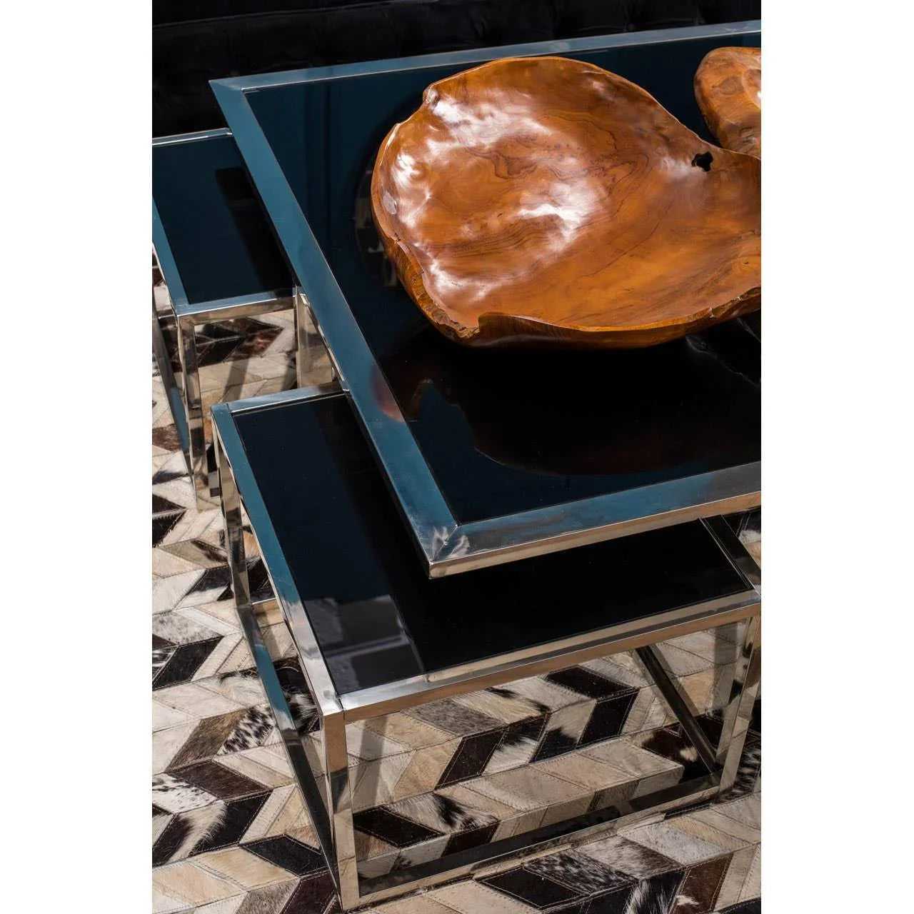 Glass and chrome coffee tables with natural wood centerpiece on geometric rug