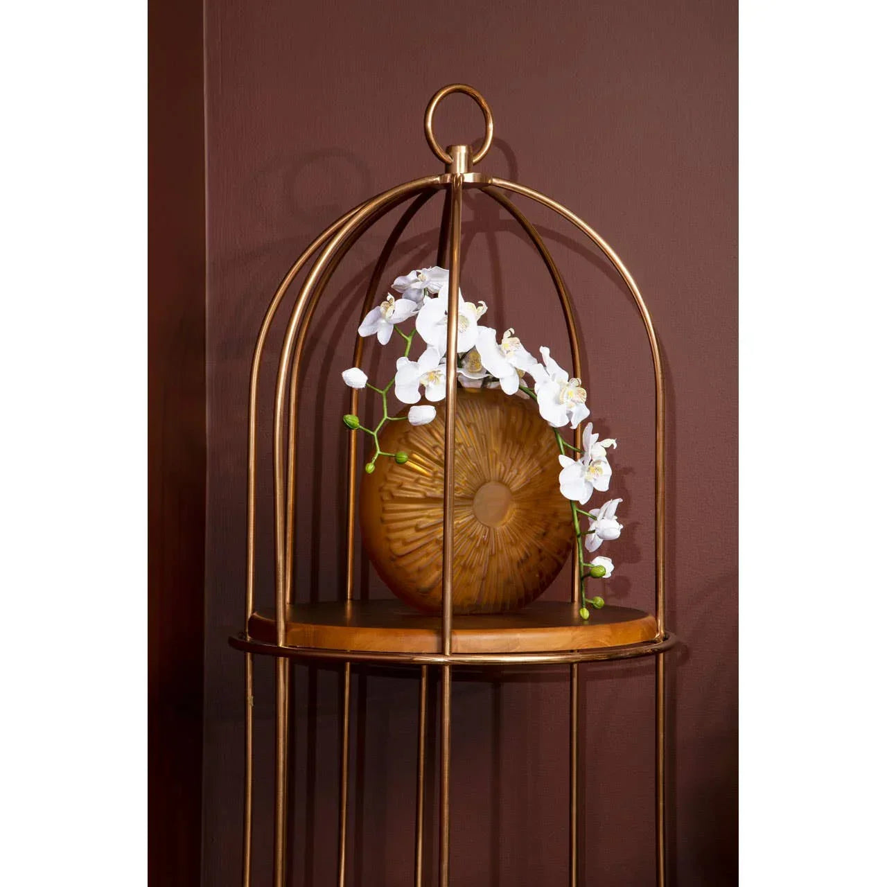 Gold accent table with decorative brown vase and white artificial orchids on display shelf