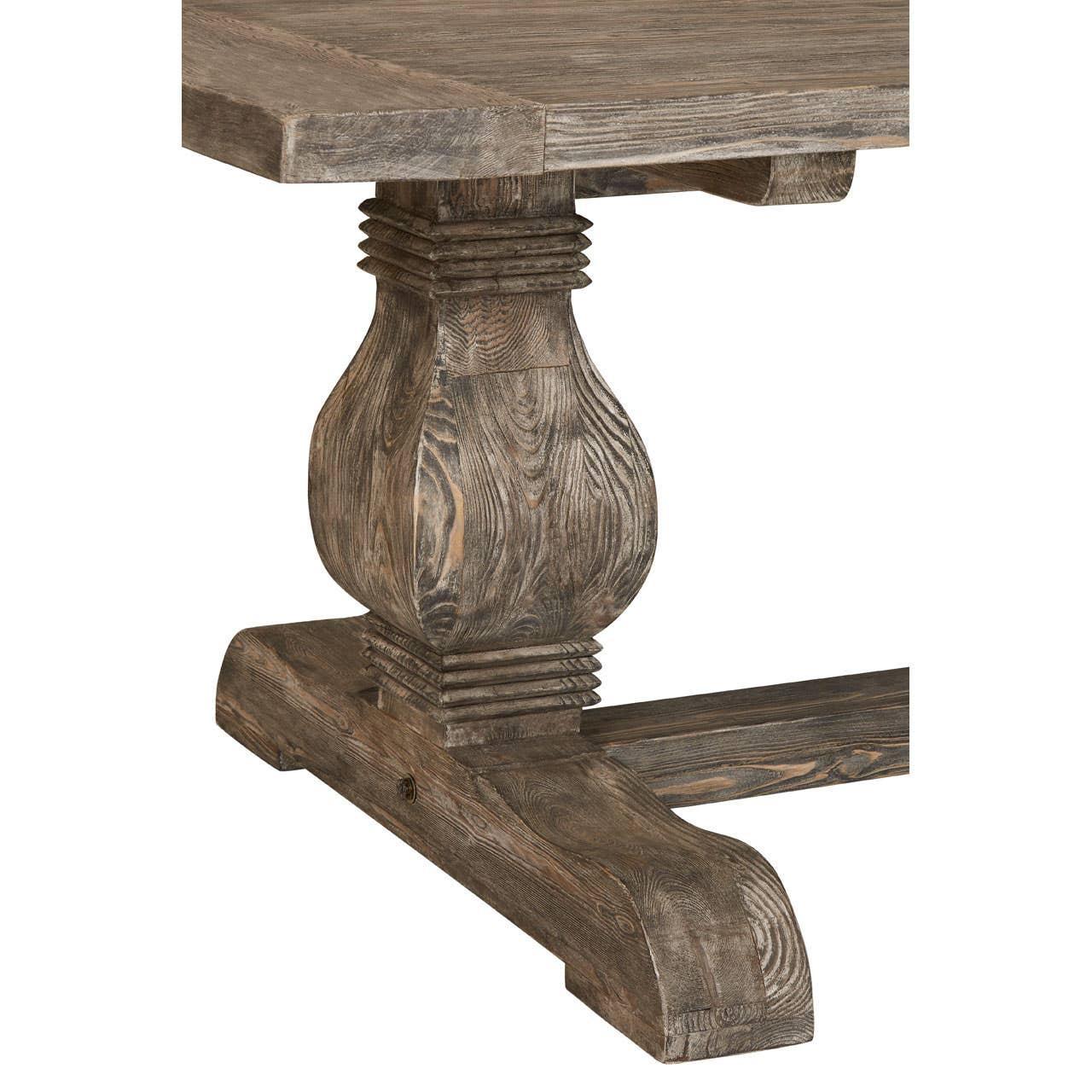 Rustic wooden dining table with carved pedestal leg and wood grain texture close up