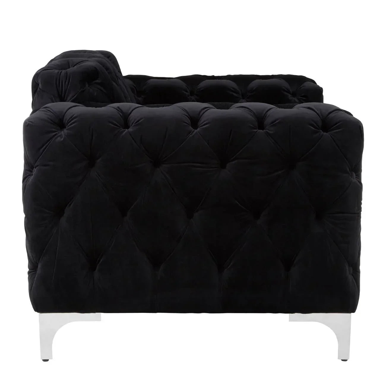 Side view of black velvet sofa with deep tufted upholstery and chrome legs