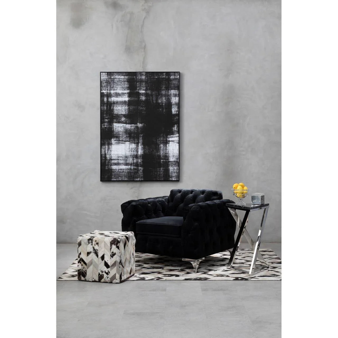 Black velvet armchair with chrome legs, patterned ottoman and rug in modern living room