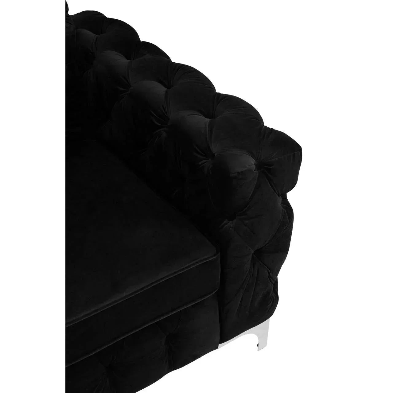 Black velvet sofa corner with deep buttoned tufted arm and chrome leg detail
