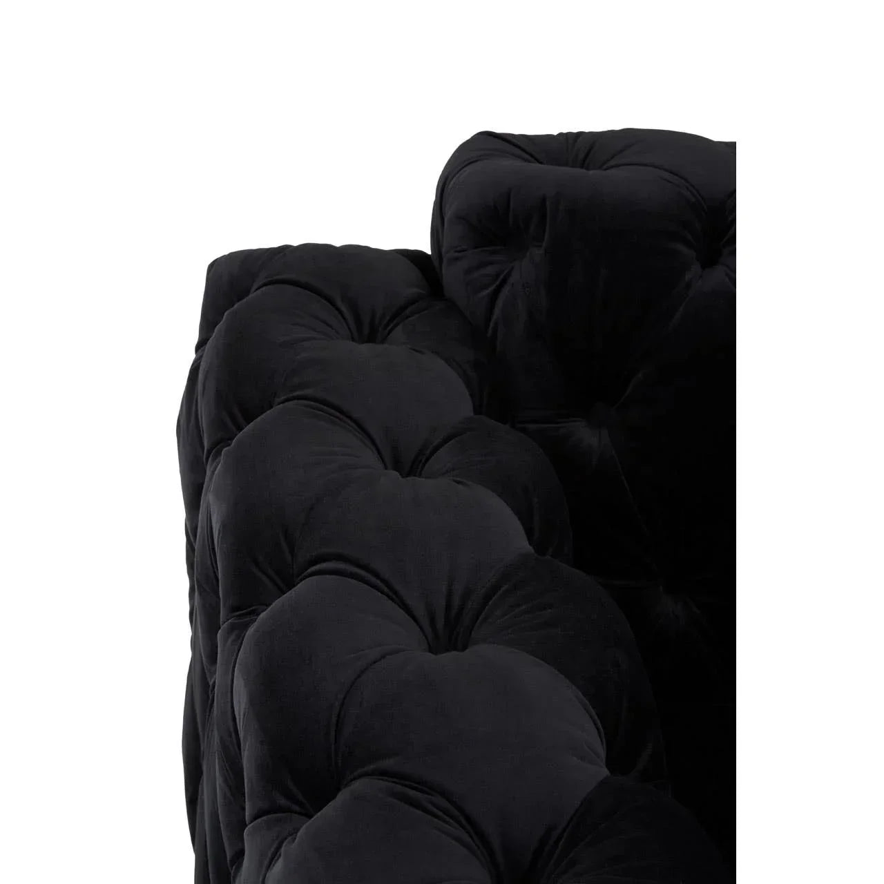 Black velvet sofa close-up showing deep button tufted upholstery