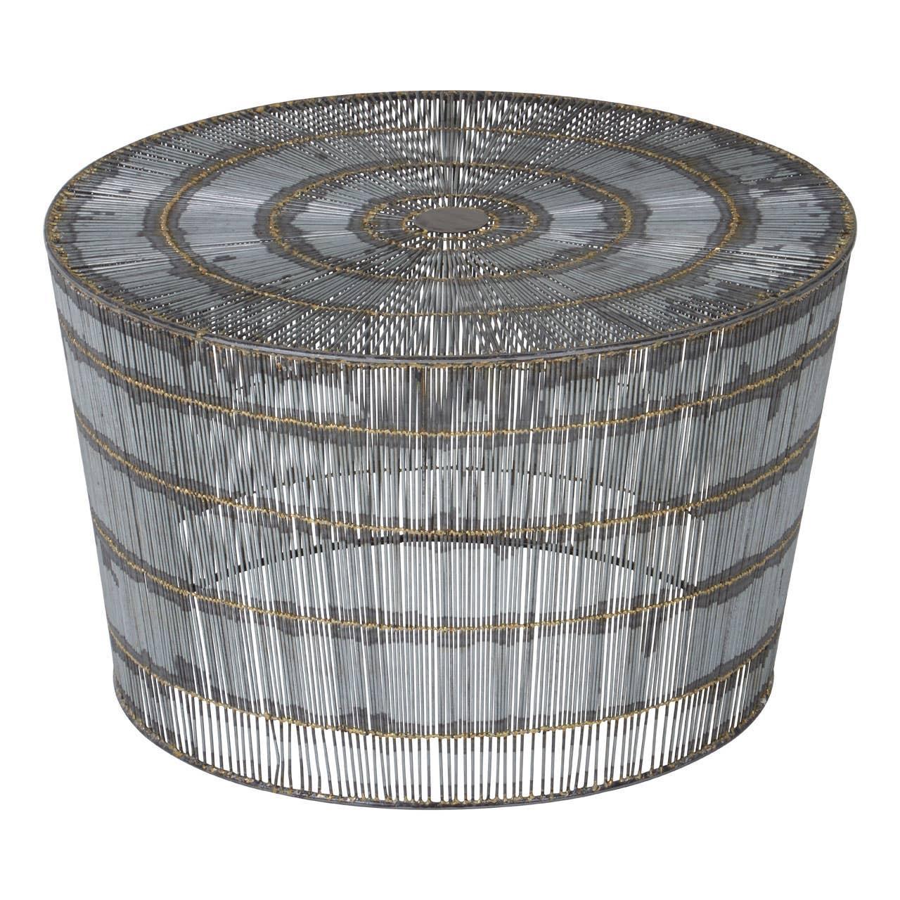 Round metal coffee table with wire frame design and circular pattern top