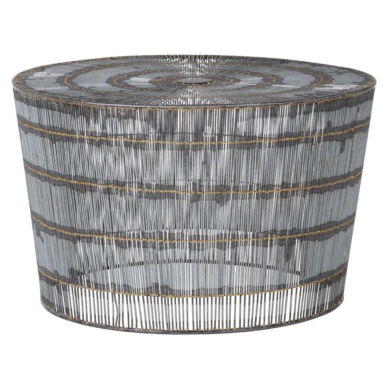Round metal coffee table with gold accent bands and wire frame design