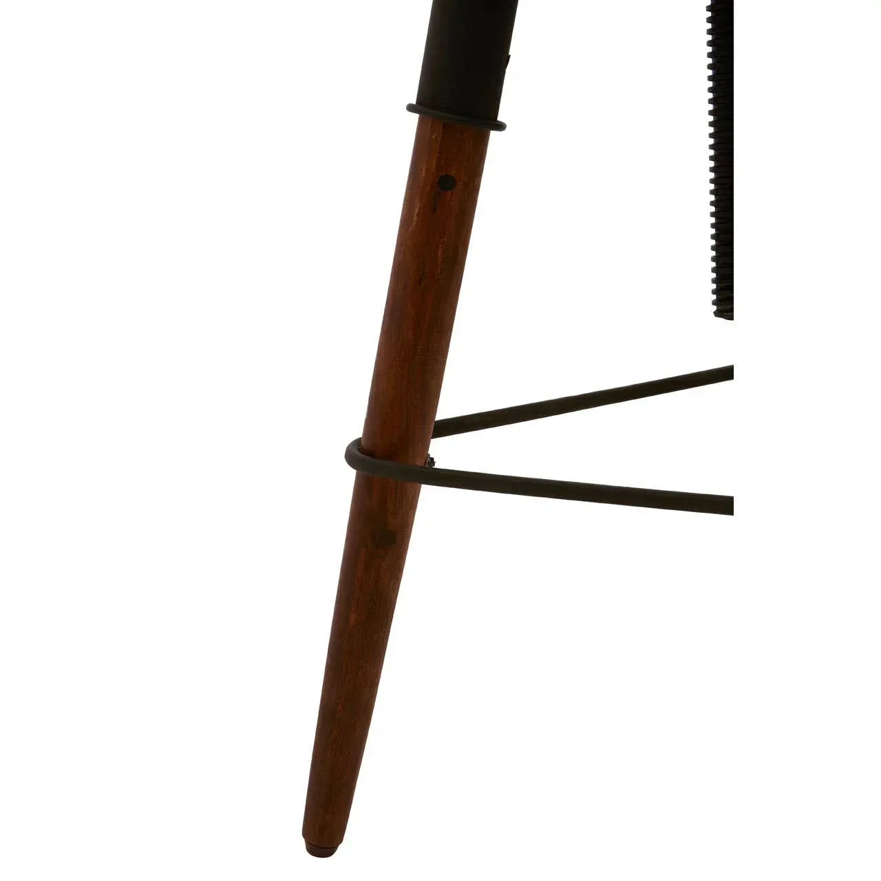 Wooden chair leg with black metal footrest and support bar close-up