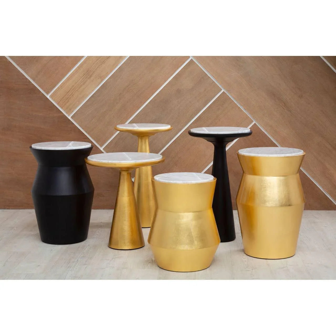 Gold and black metal side tables with white marble tops in modern geometric shapes