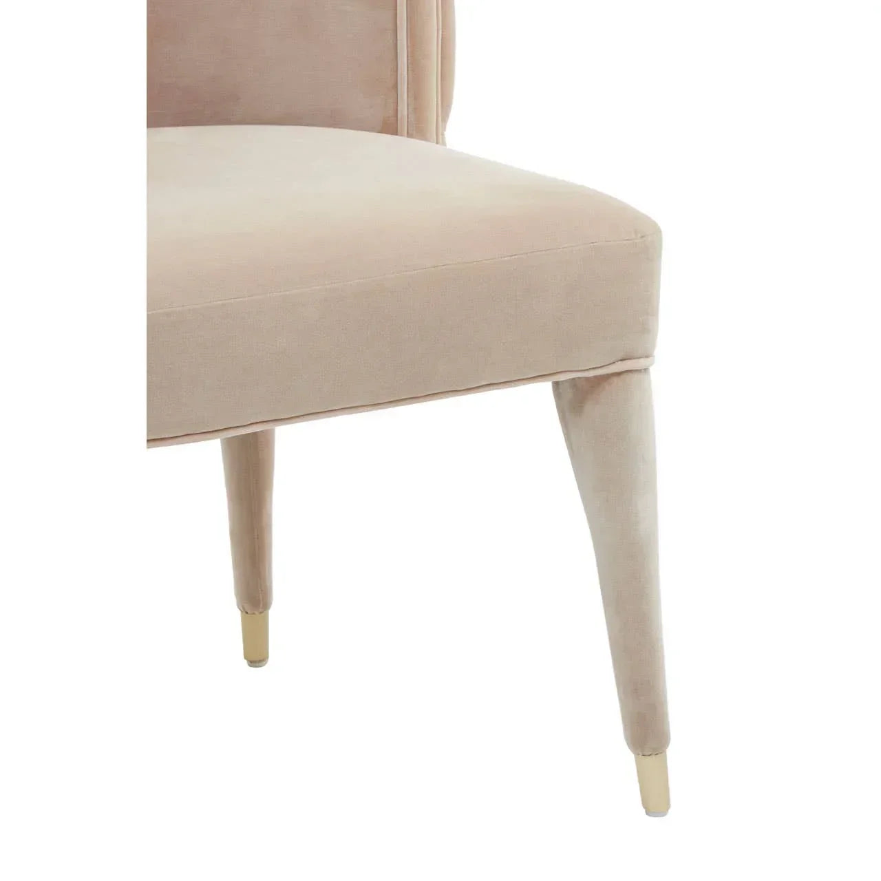 Beige velvet dining chair closeup with tapered legs and gold metal tips