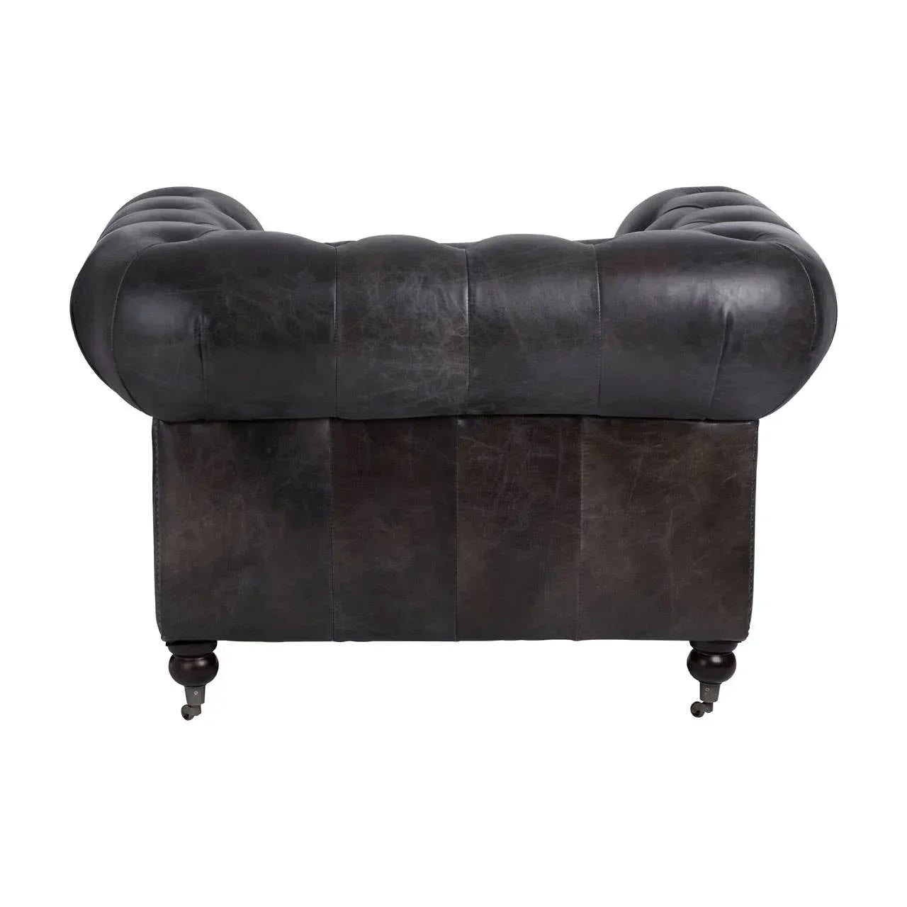Back view of dark leather chesterfield sofa with tufted backrest and turned wooden legs