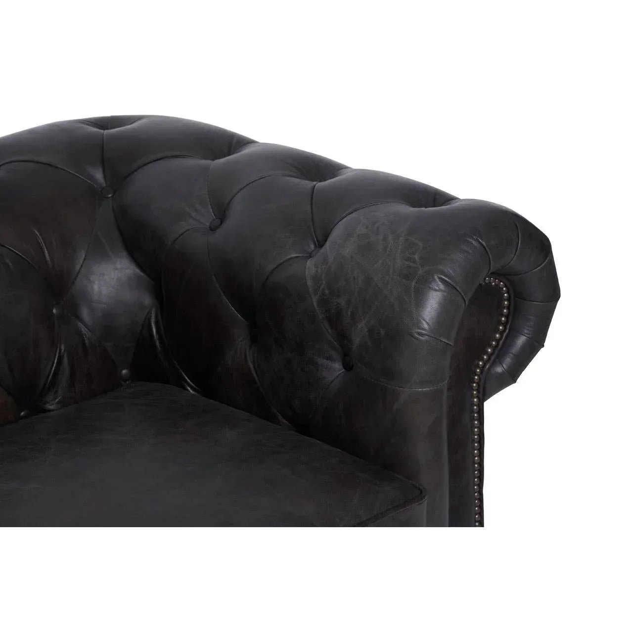 Dark leather sofa armrest with tufted back and nailhead trim detail