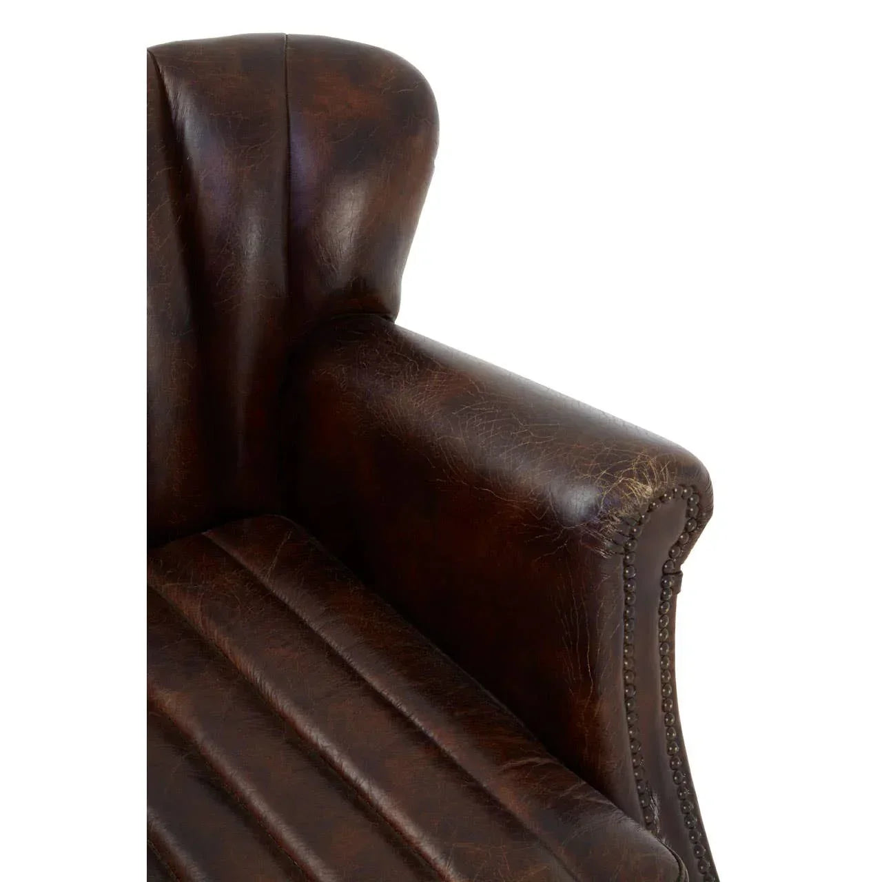 Close-up of brown leather armchair with studded armrest and ribbed seat detail
