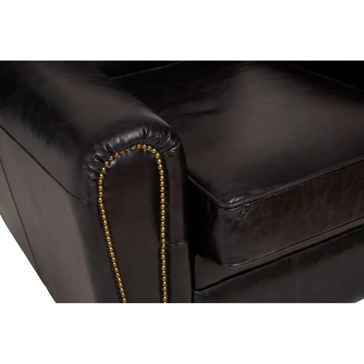 Close up of brown leather sofa armrest with brass stud detailing and seat cushion