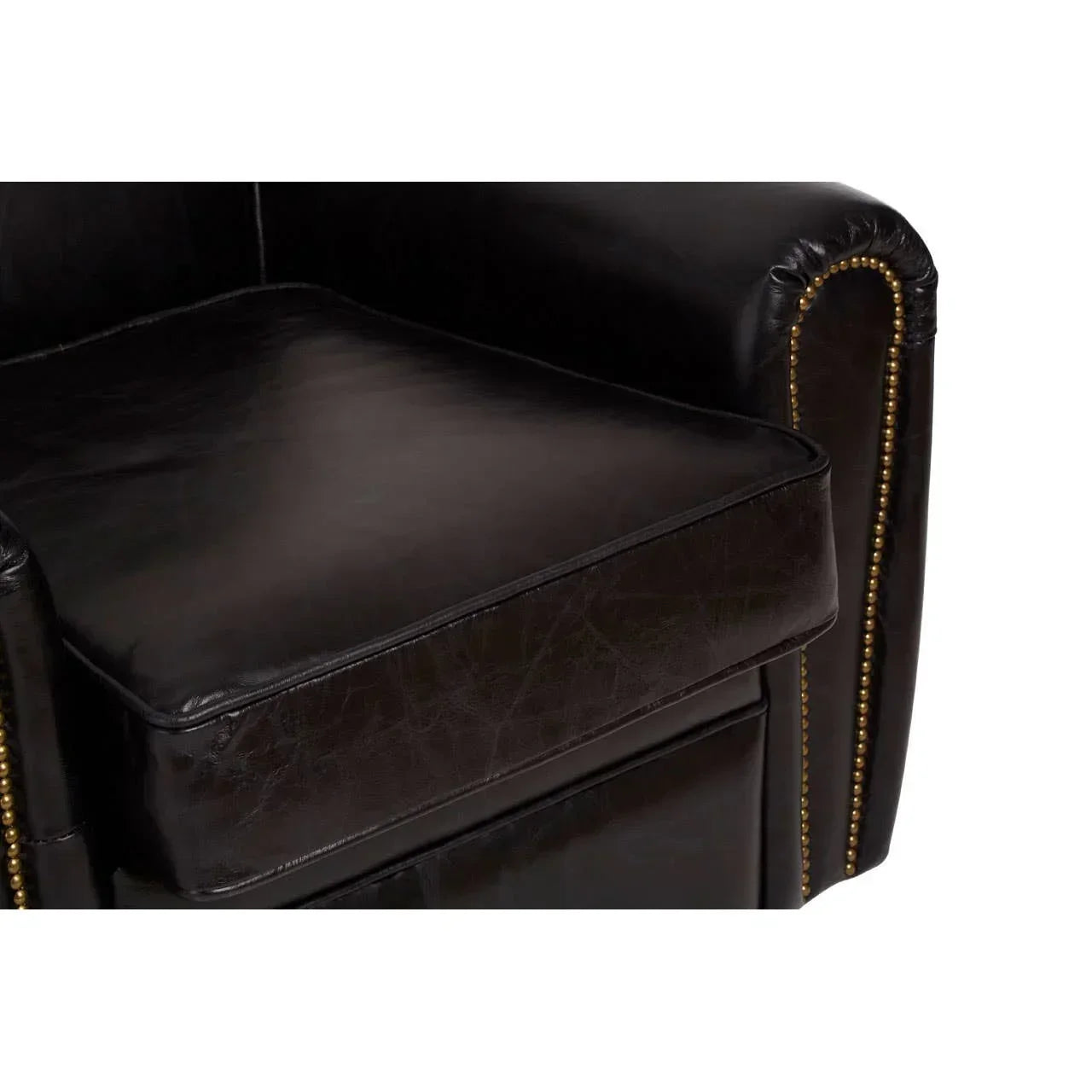 Black leather armchair seat with brass stud detailing on rolled armrest