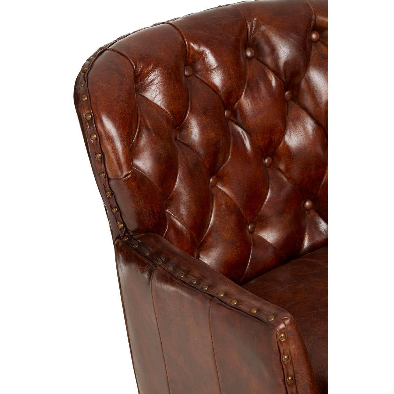 Brown leather armchair with deep button tufting and brass stud detailing