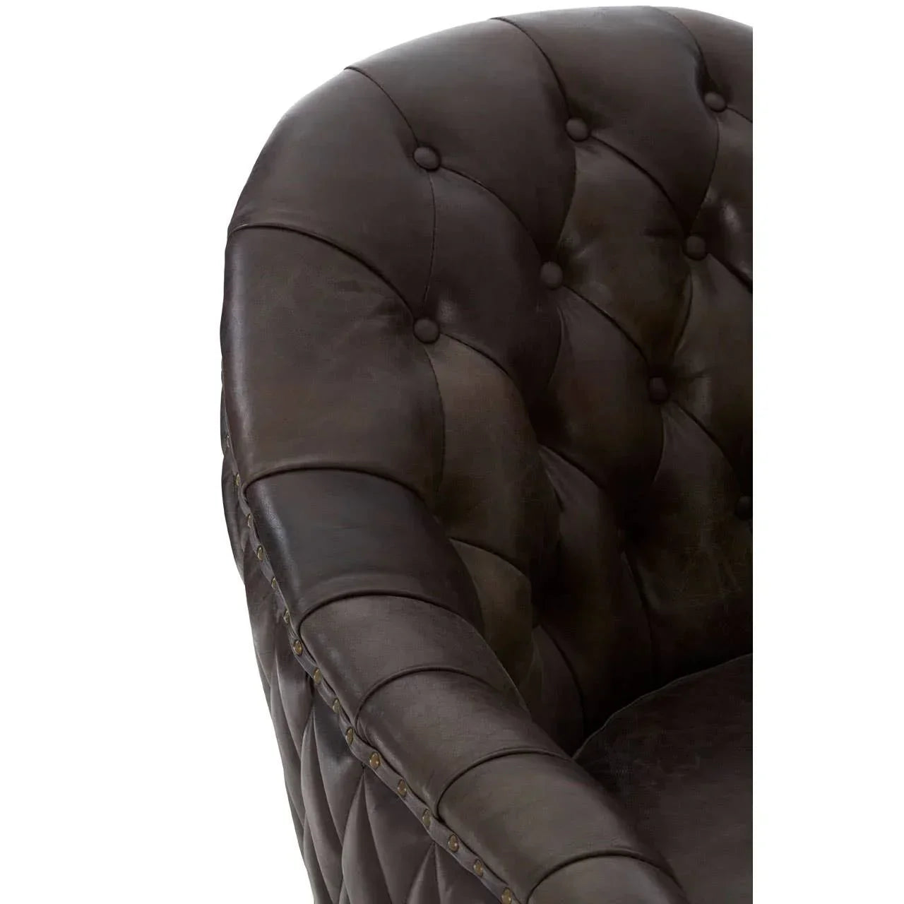 Closeup of brown leather armchair with deep button tufted back and stud detailing