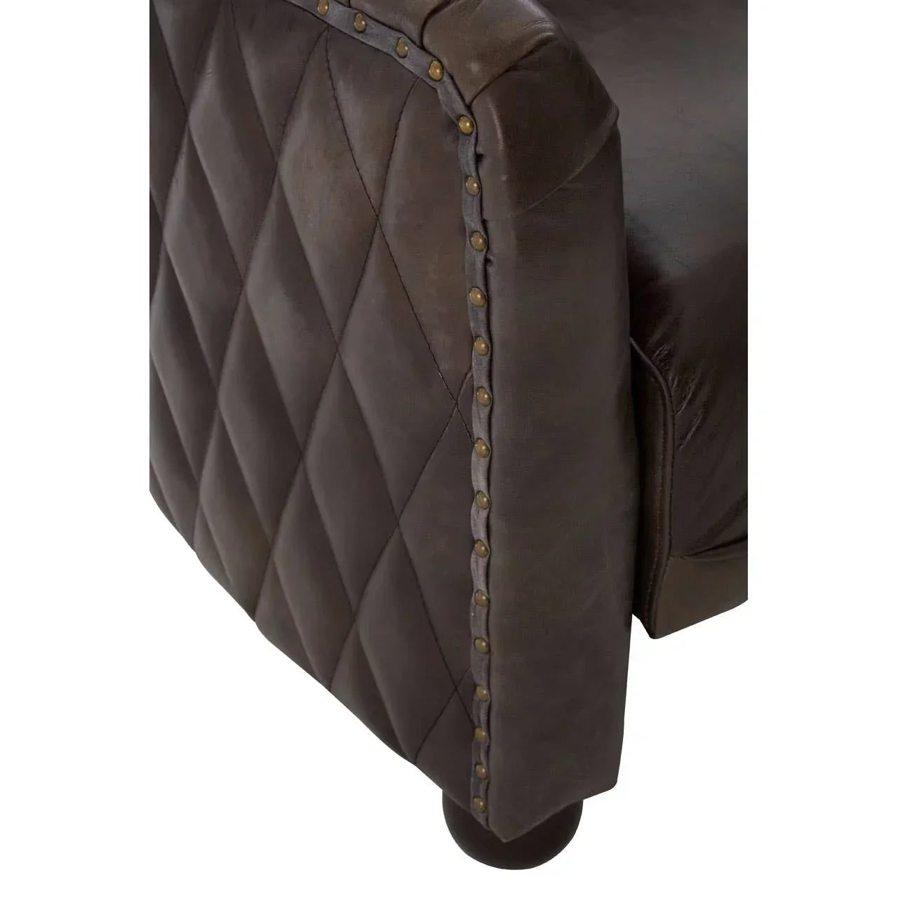 Brown leather sofa arm with diamond quilting and brass nailhead trim