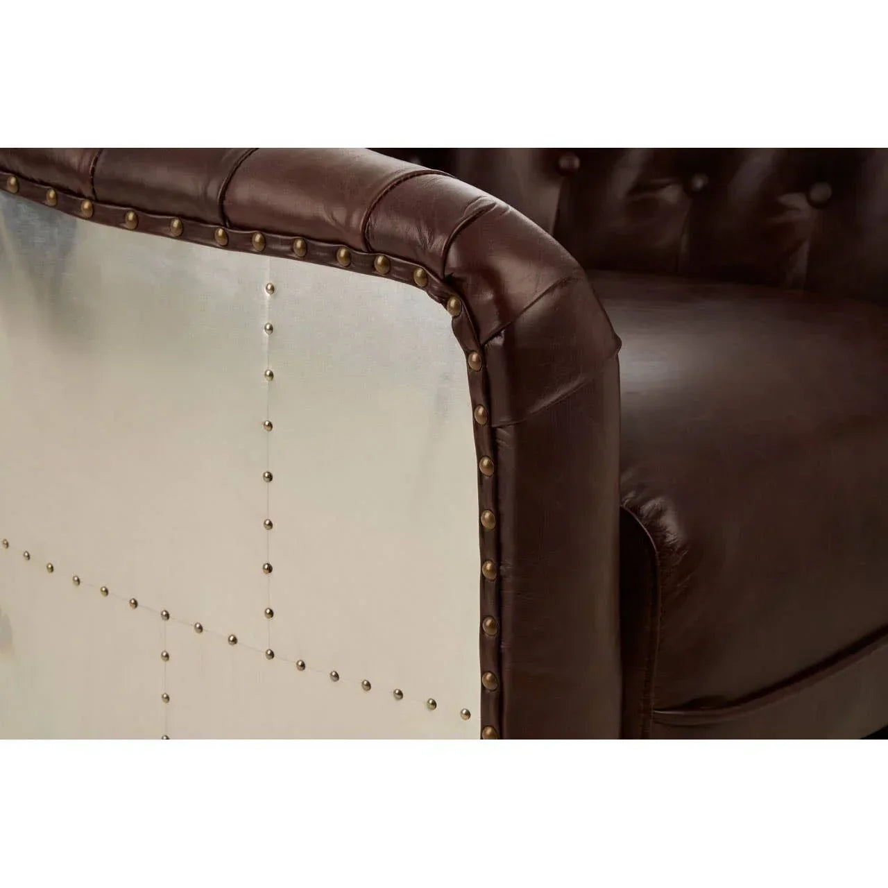 Brown leather sofa with metal side panel and decorative brass studs close-up