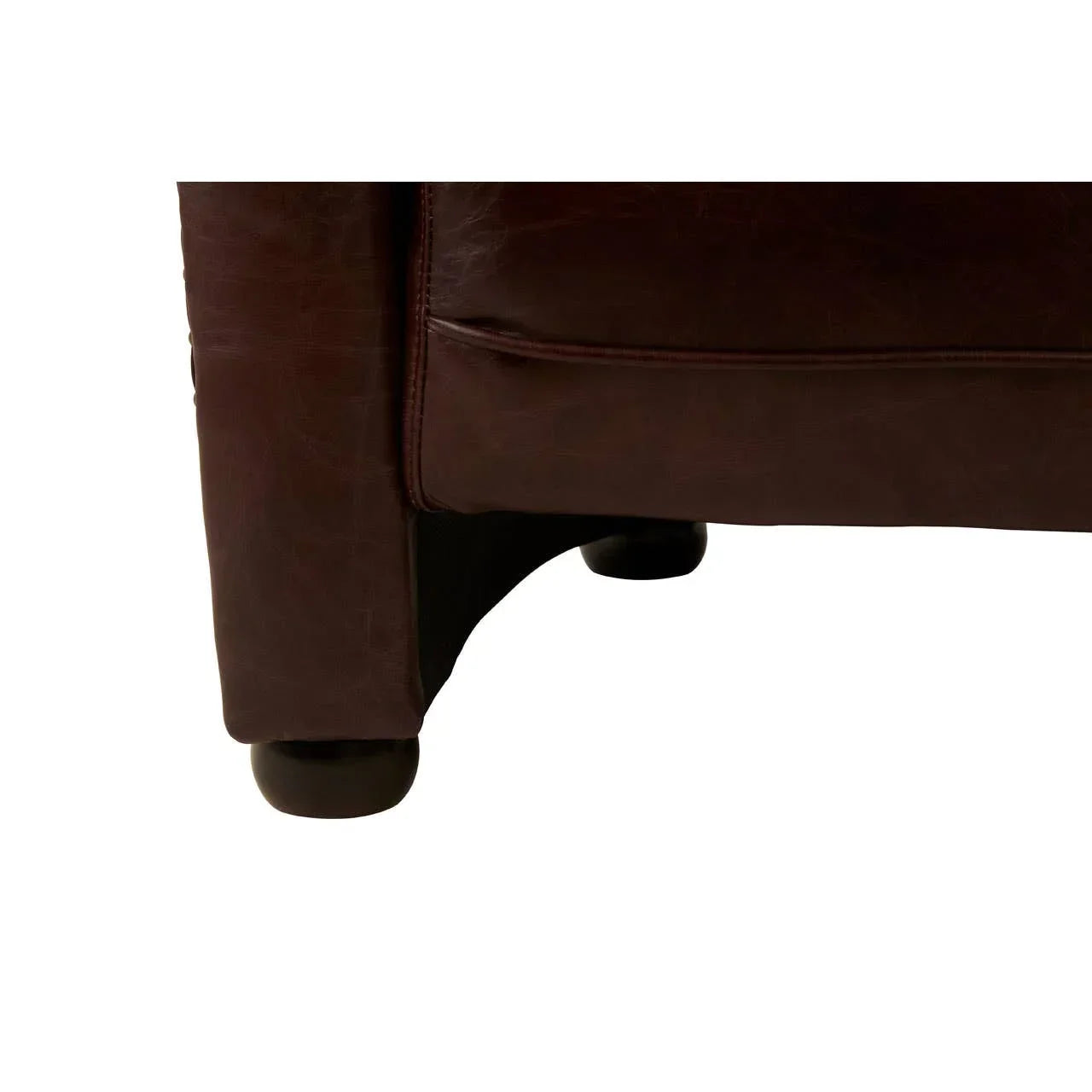 Close-up of brown leather sofa corner with rounded wooden leg