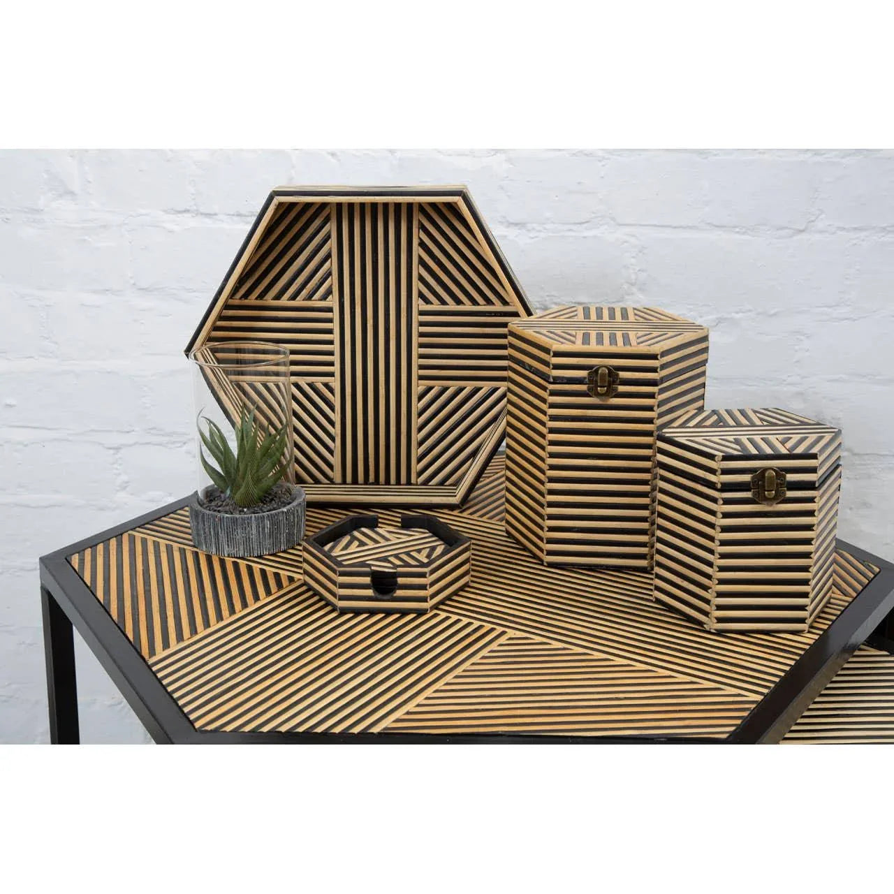 Geometric bamboo storage boxes with black striped pattern on modern console table