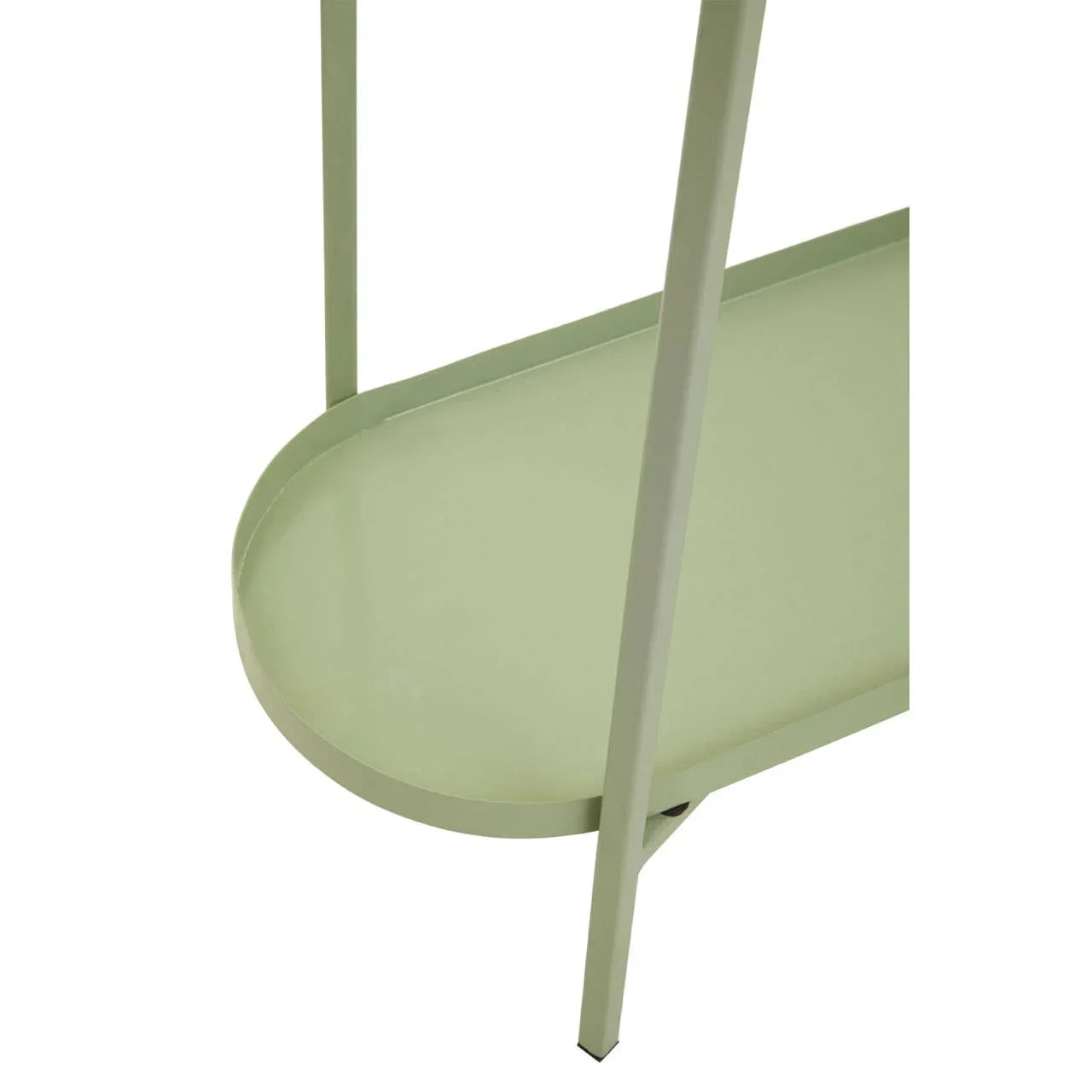 Closeup of sage green metal side table with oval lower shelf and slim legs