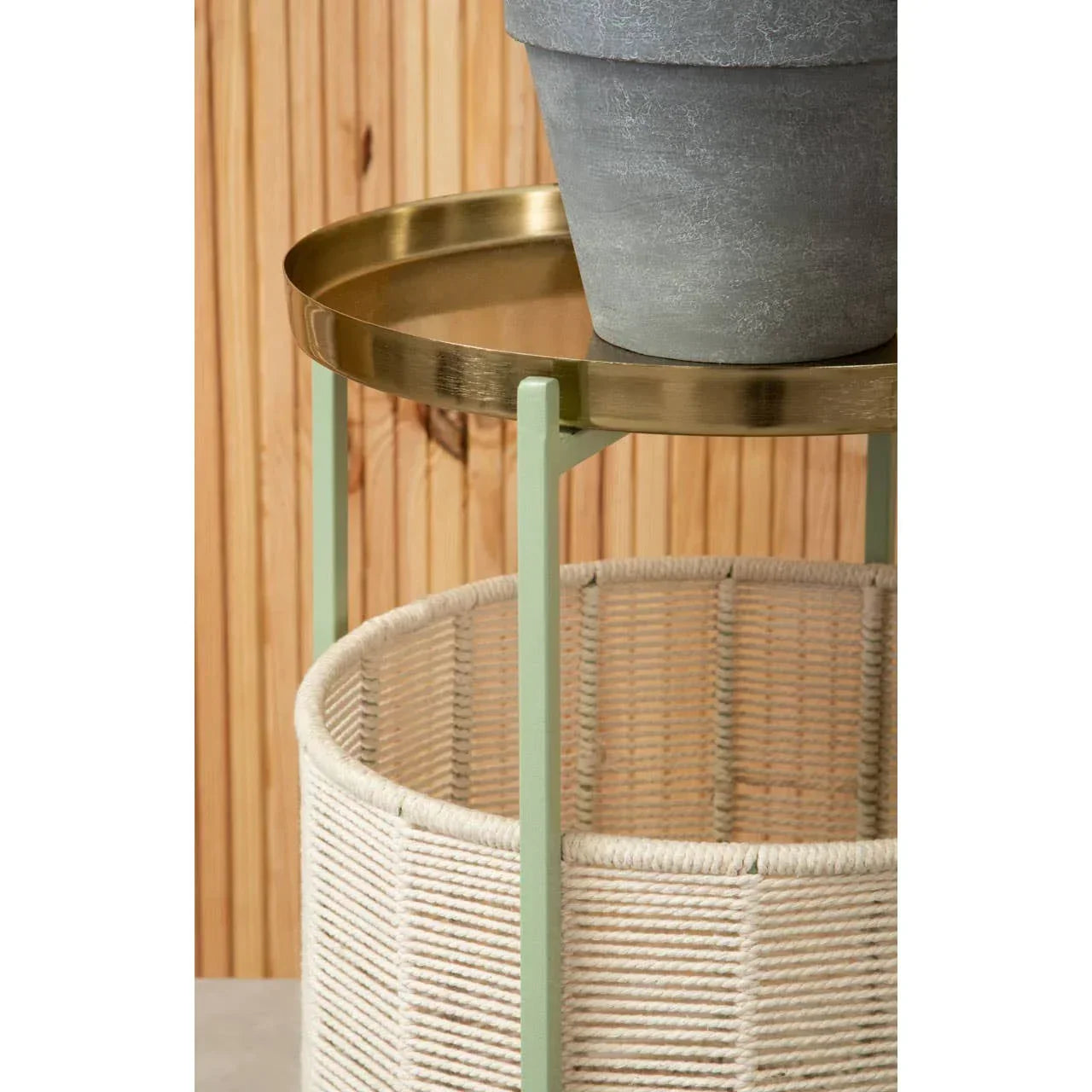 Round side table with gold metal tray top, green legs, and woven rope storage basket