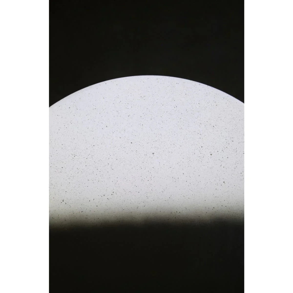 Close view of round white stone table top with speckled surface