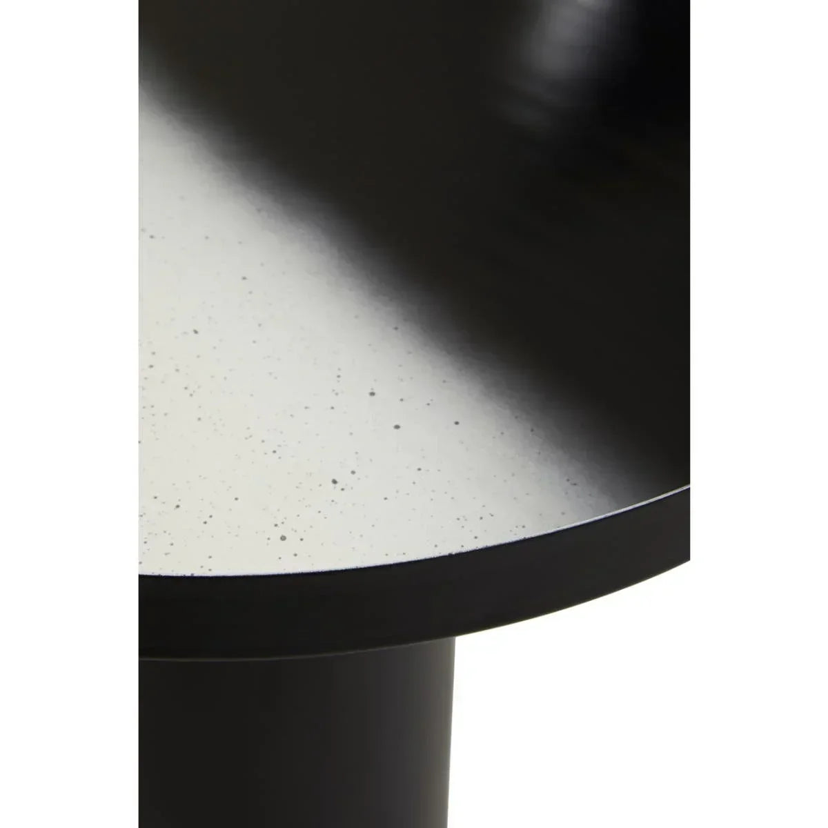 Close view of round black dining table with smooth speckled surface