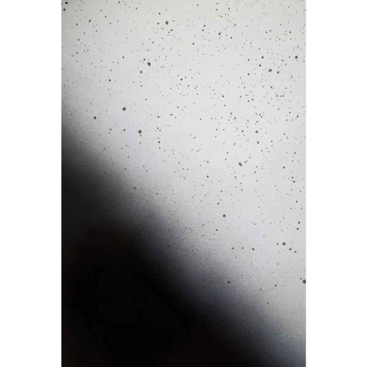Closeup of speckled black and white glass surface, modern mirror detail