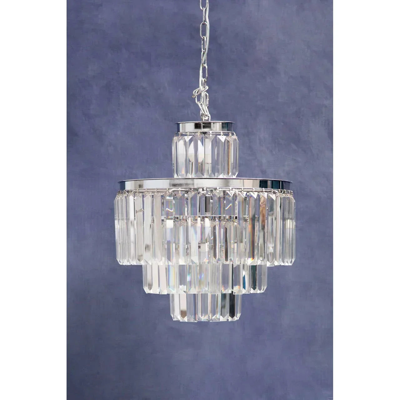 Crystal chandelier pendant light with chrome finish against blue wall
