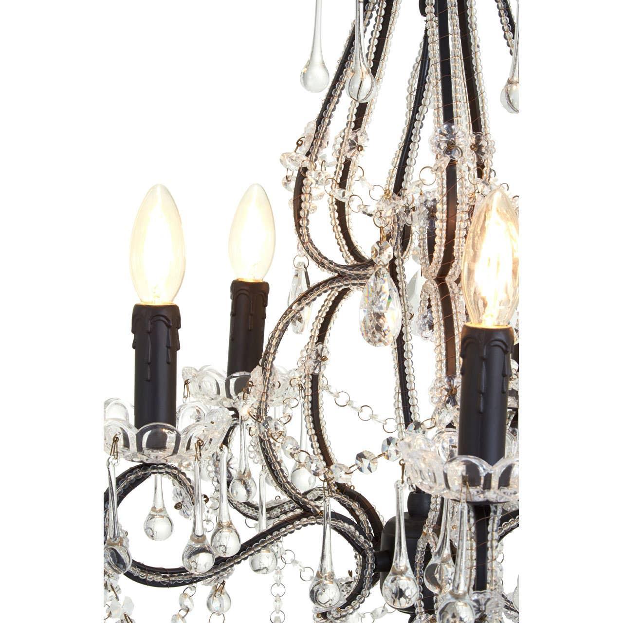 Close-up of crystal chandelier with black frame, candle-style bulbs, and hanging glass droplets