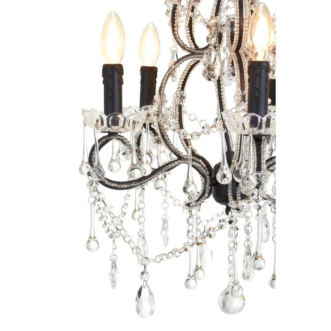 Crystal chandelier detail with black arms, glass droplets, and candle-style bulbs
