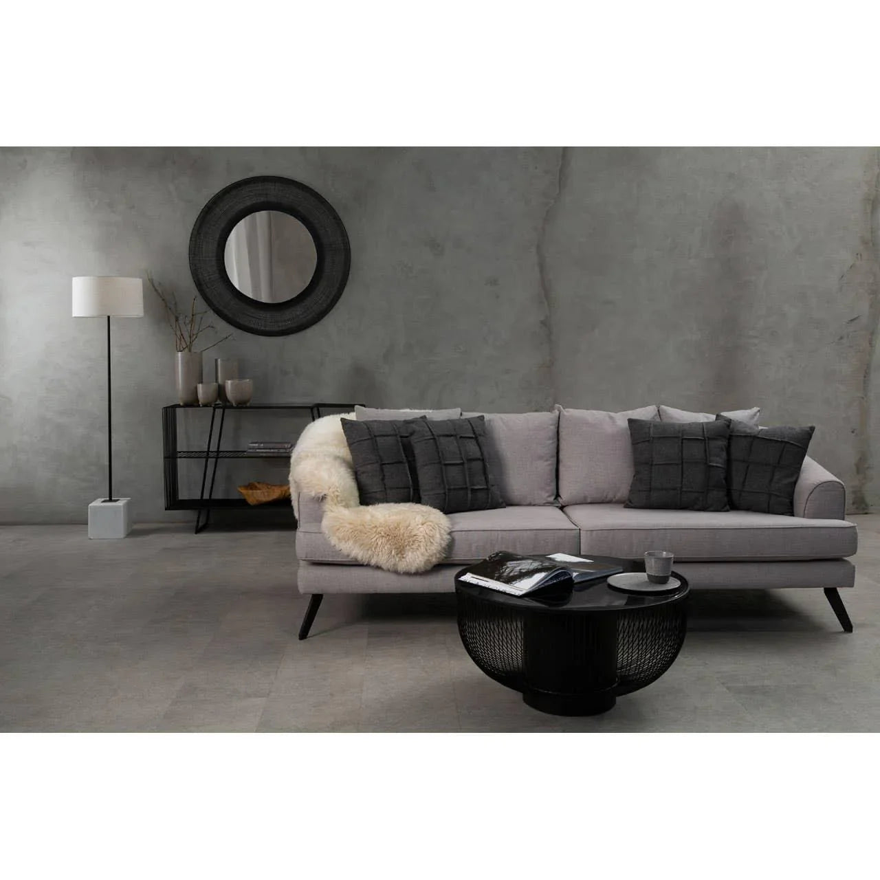 Grey fabric sofa with dark scatter cushions and black coffee table in modern living room