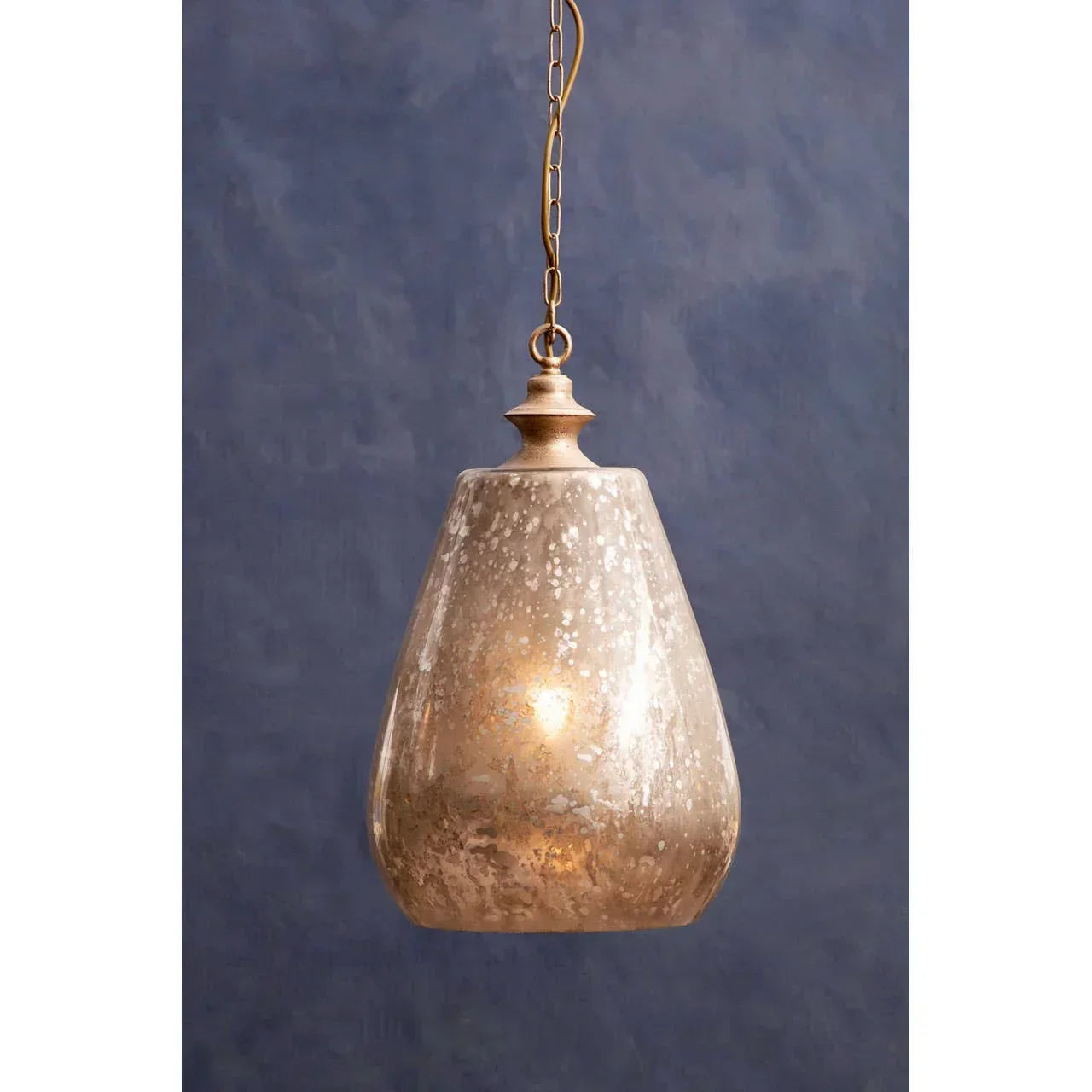 Antique gold glass pendant light with chain against textured blue wall