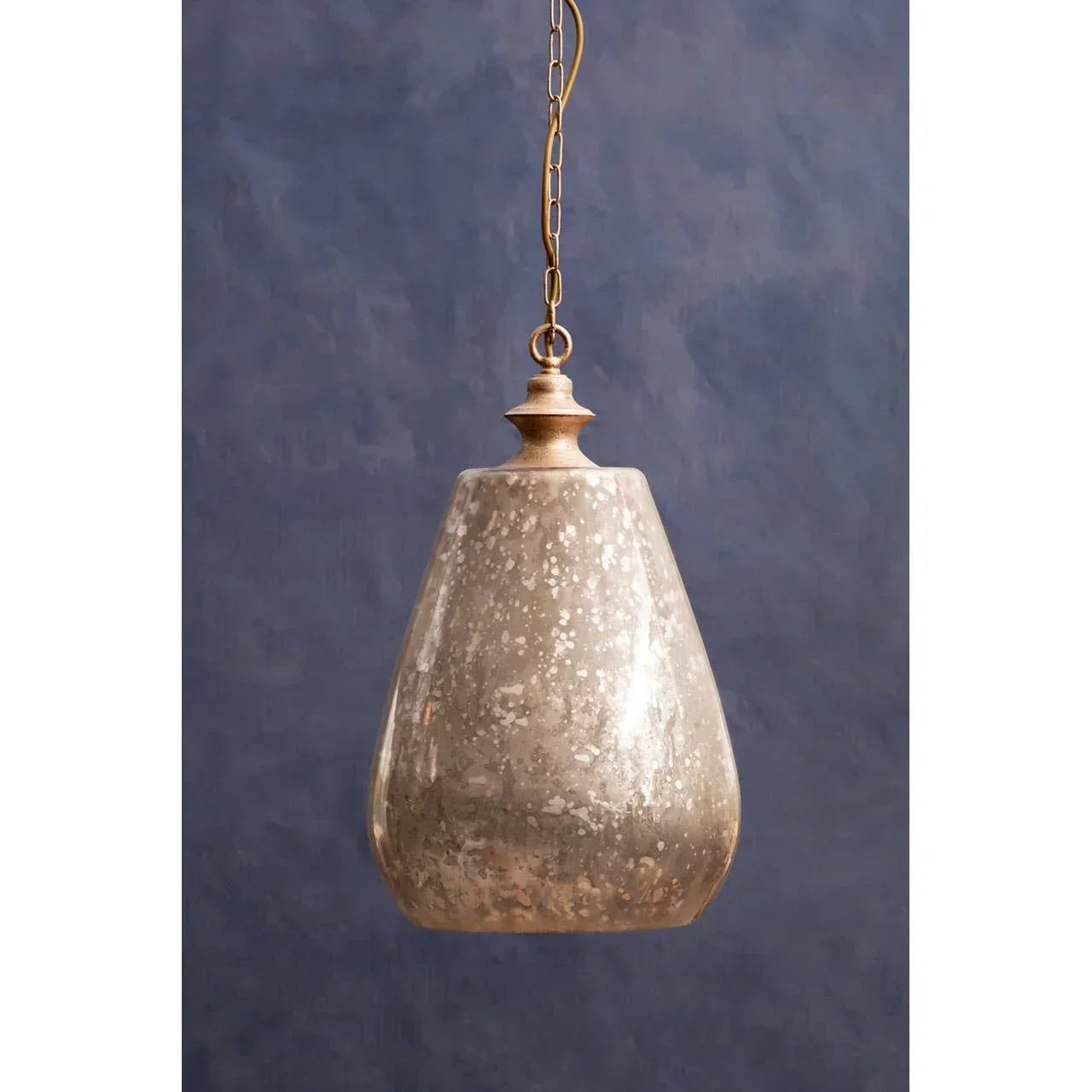 Glass pendant light with bronze chain and speckled finish against blue wall