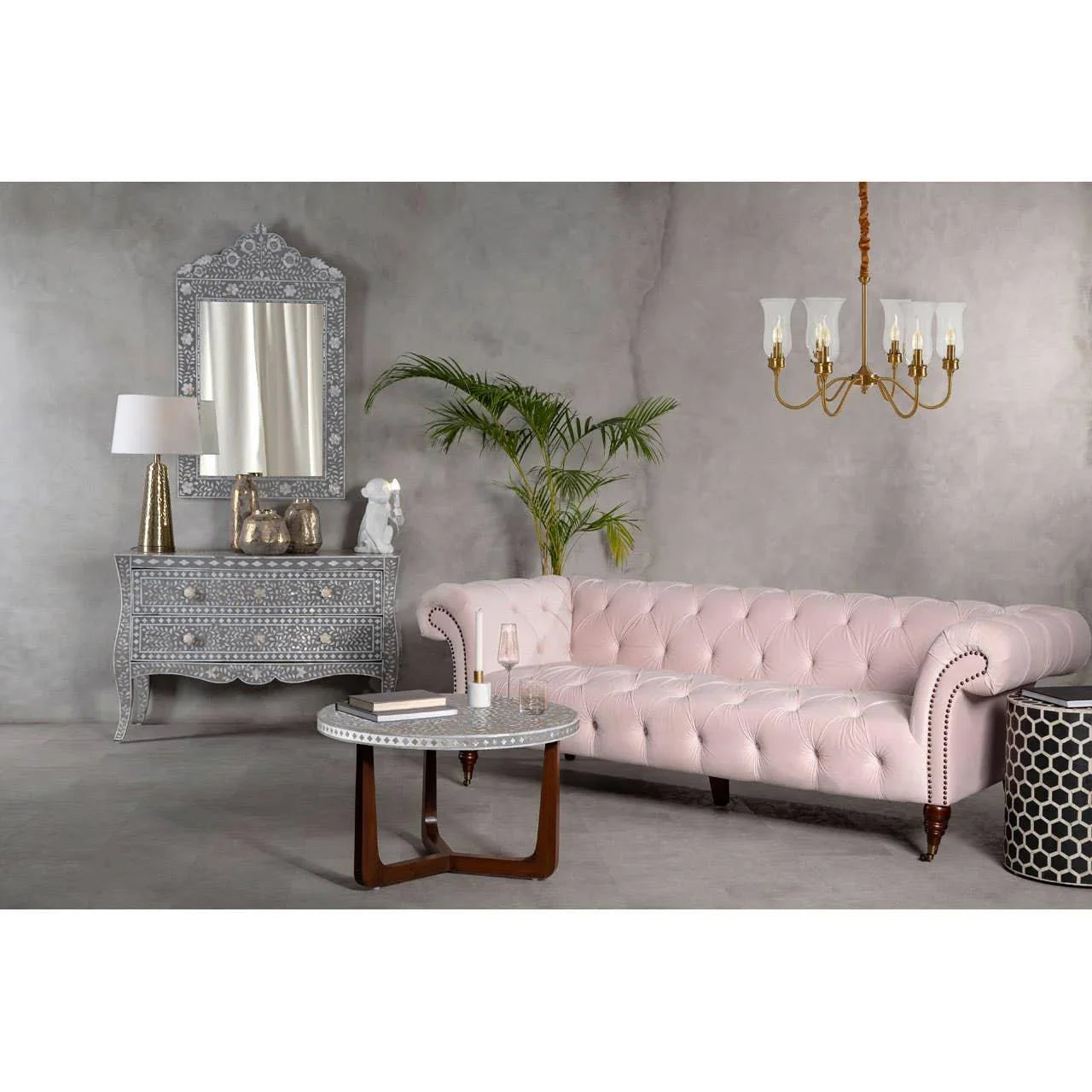 Light pink tufted sofa with round coffee table in modern living room setting