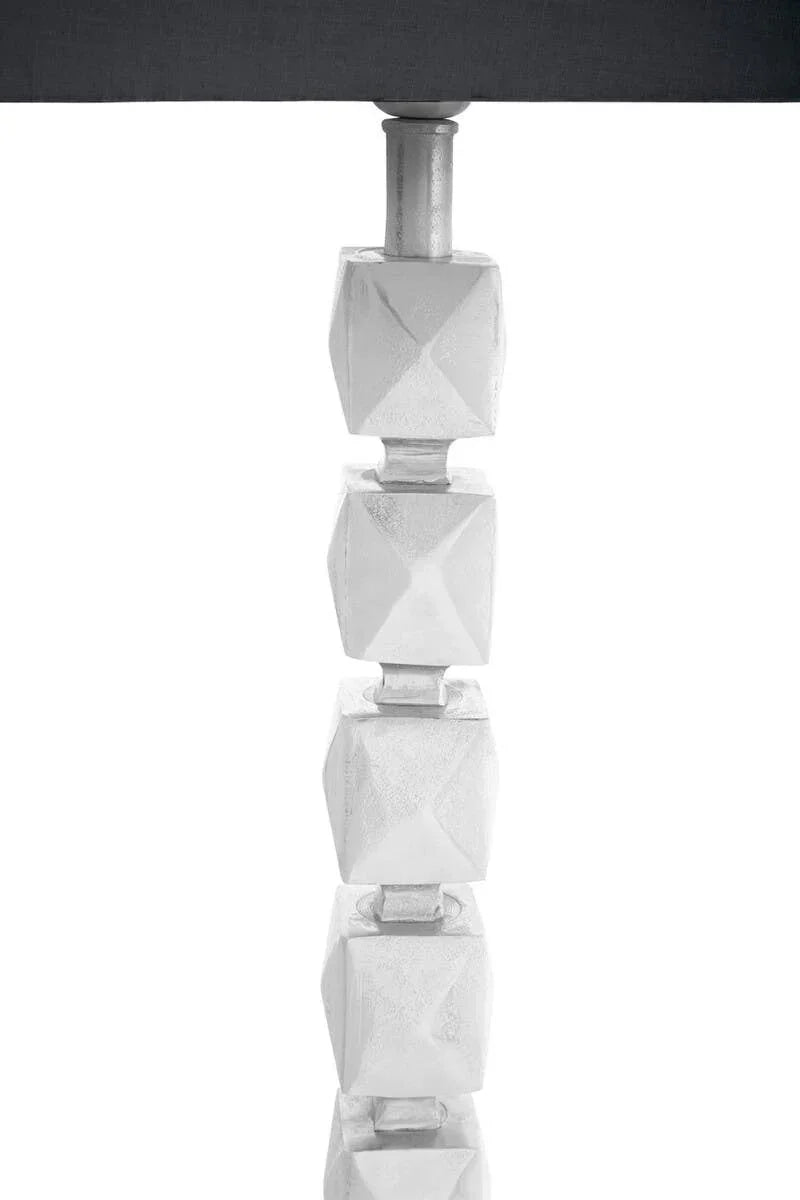 Modern table lamp with stacked geometric silver base and dark shade partial view
