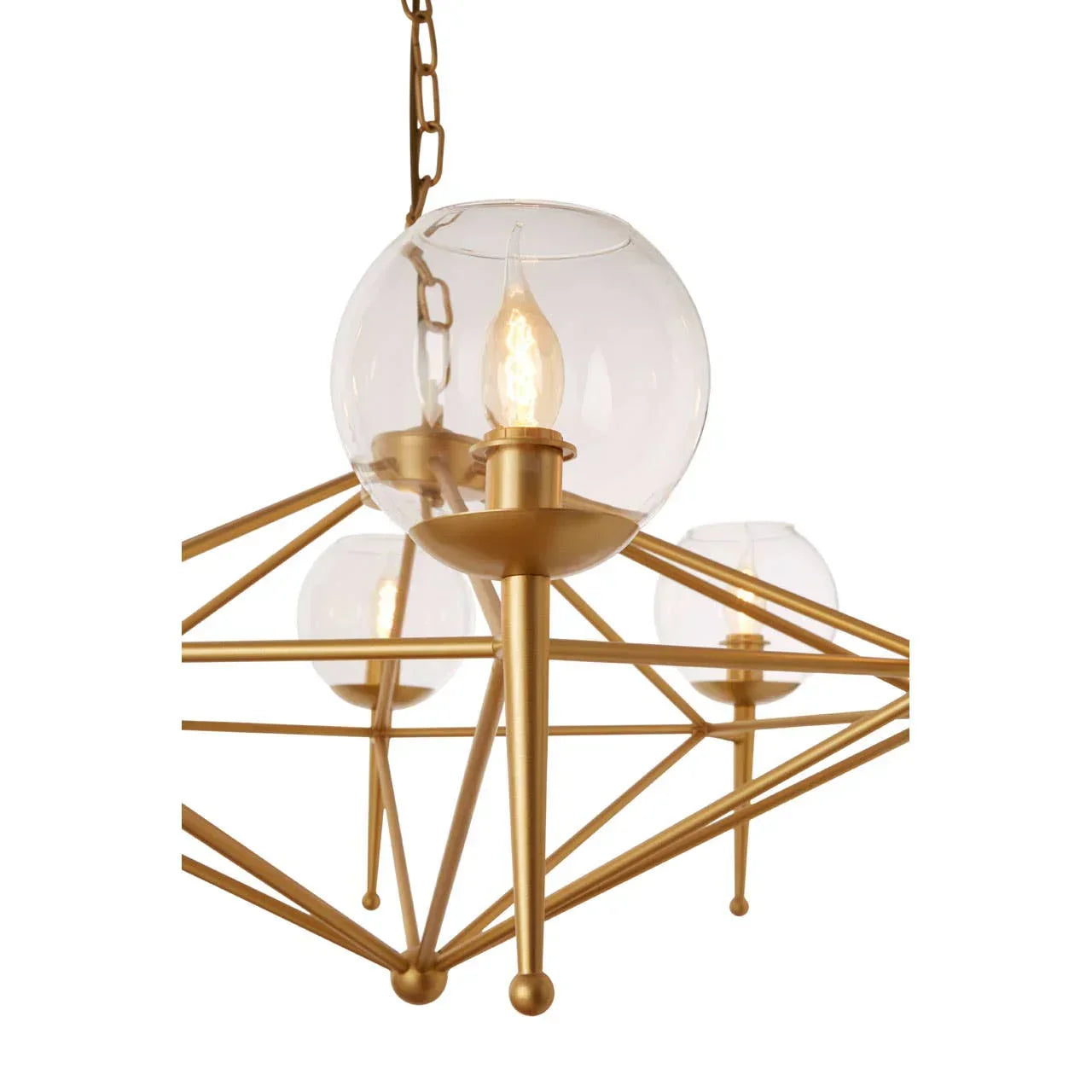 Gold chandelier with clear glass globe shades and candle-style bulbs, close view