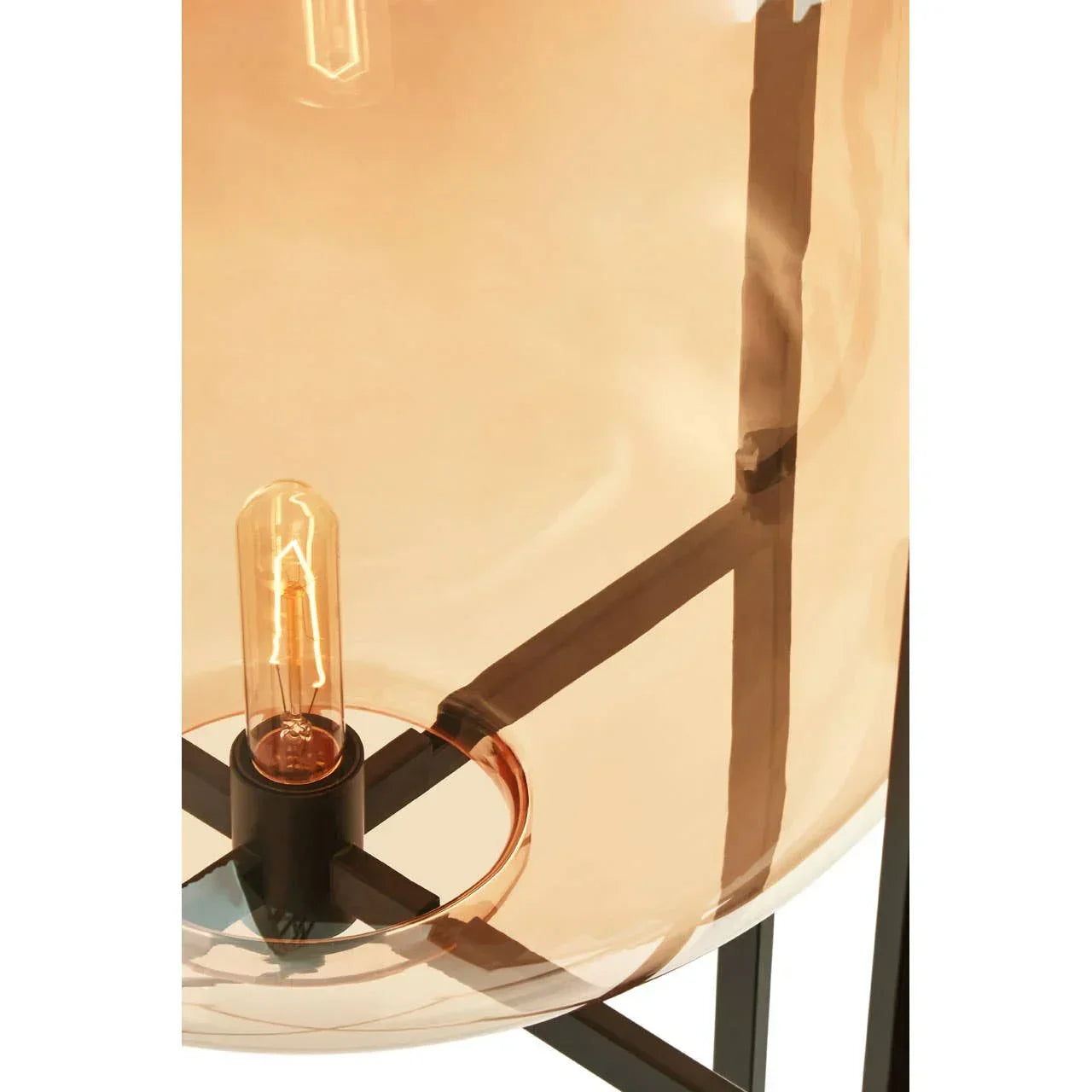 Amber glass lampshade with black metal frame and exposed bulb