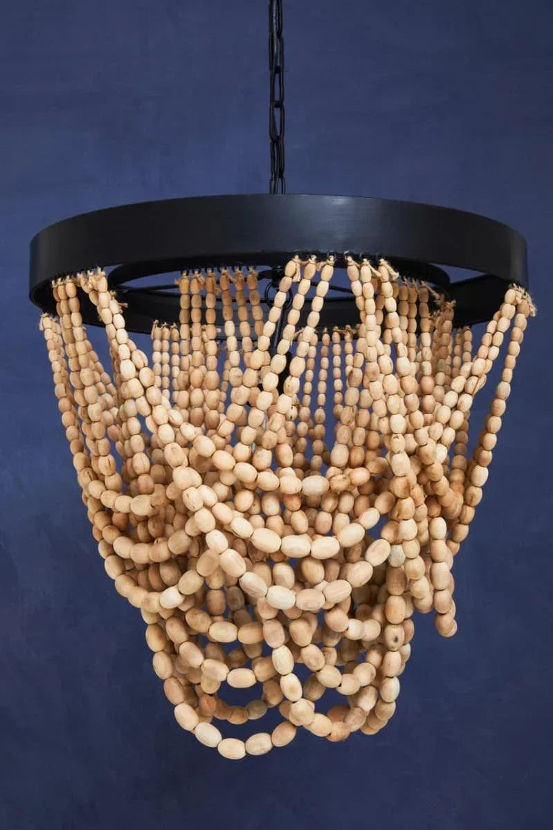 Boho wood bead chandelier with round black frame hanging against dark blue wall