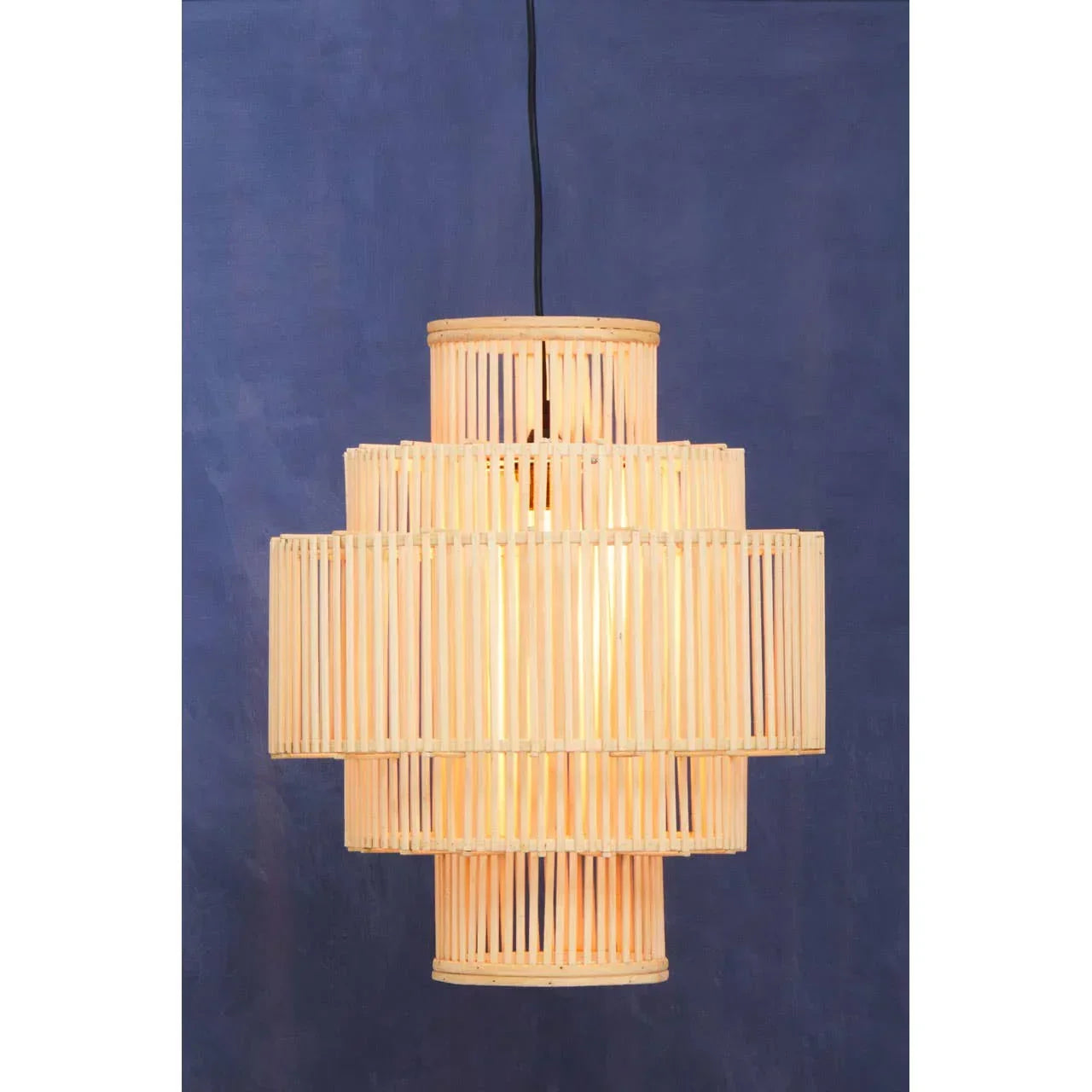 Natural rattan pendant light with tiered cylindrical design against a blue background