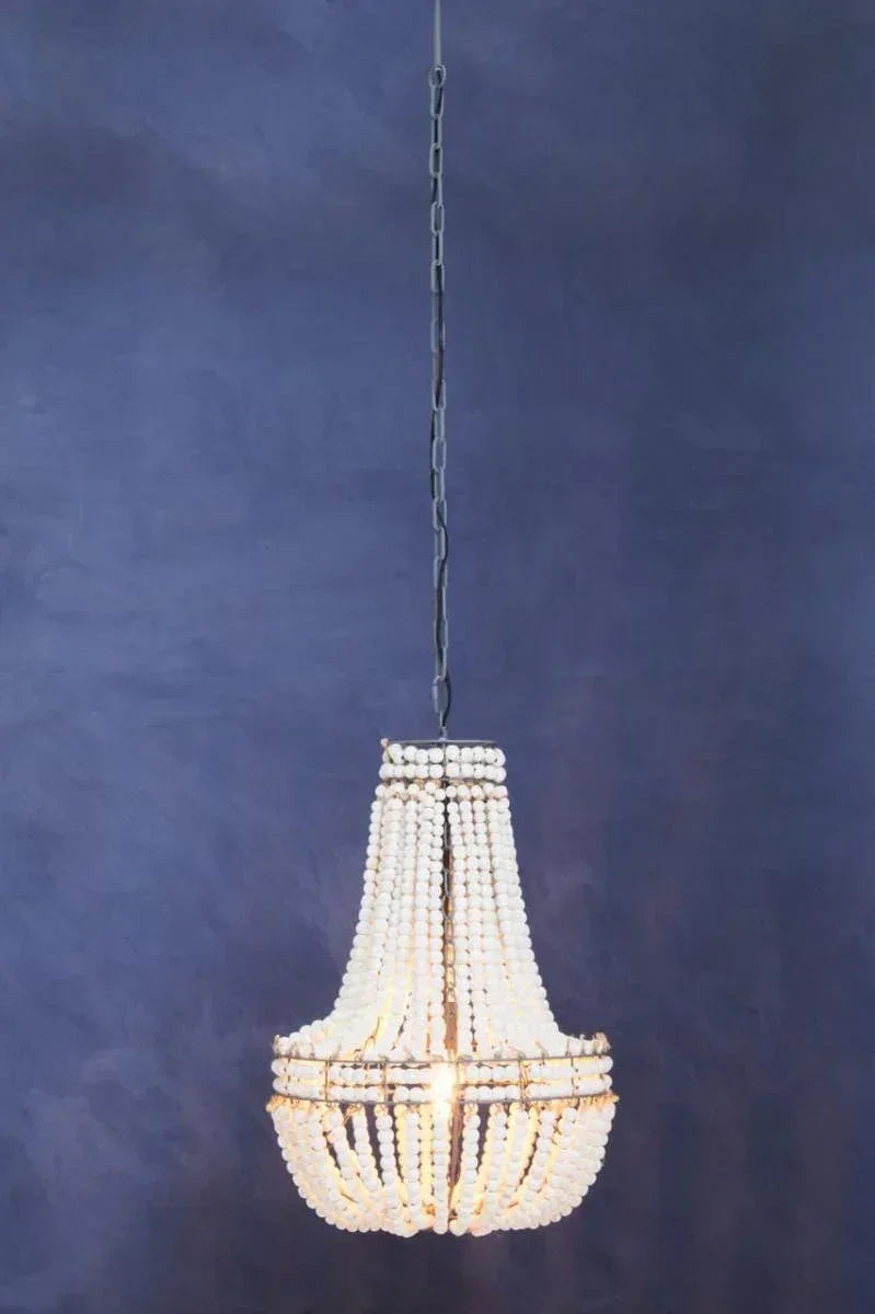 Beaded chandelier with white wooden beads and metal frame hanging against a blue wall