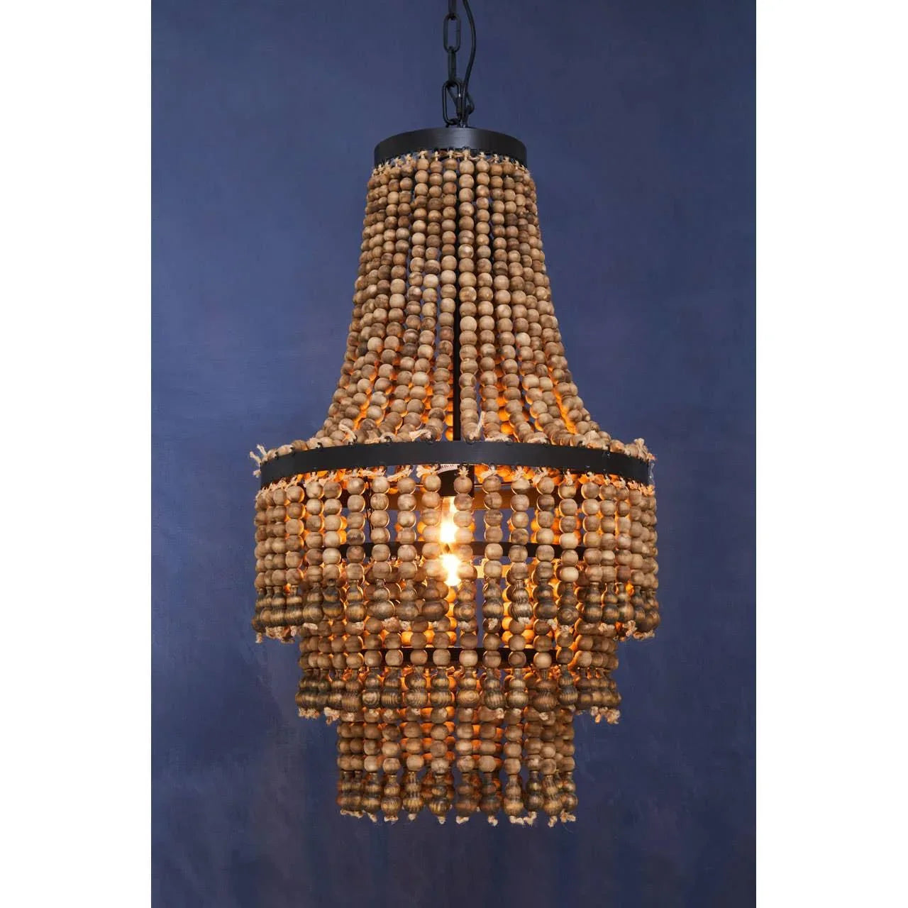 Wood bead chandelier with black frame and hanging chain against dark blue wall