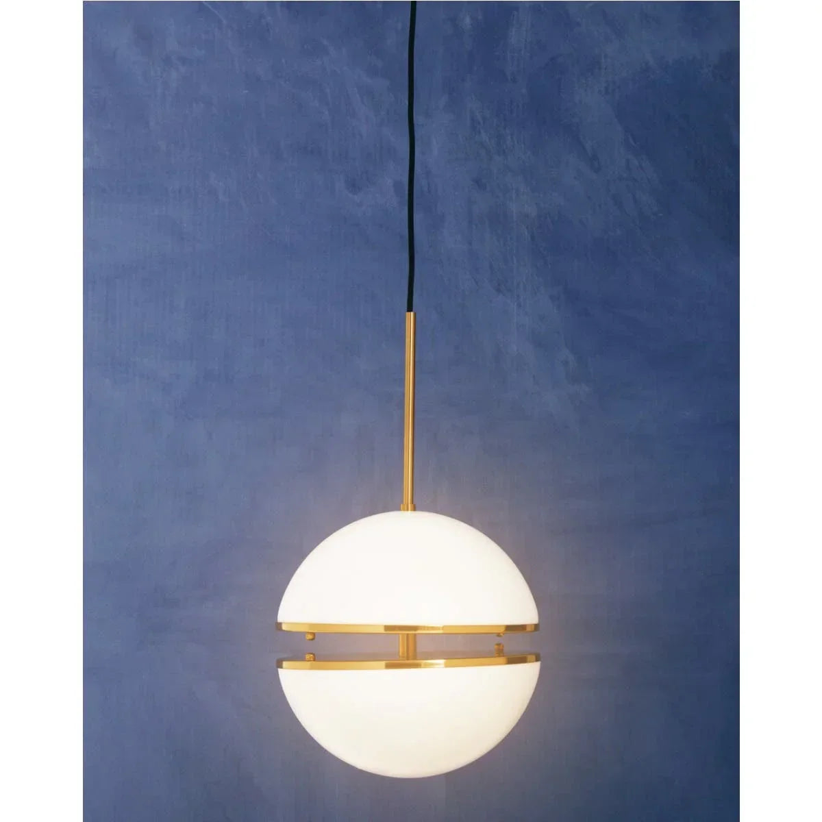 White globe pendant light with gold accents against a textured blue wall