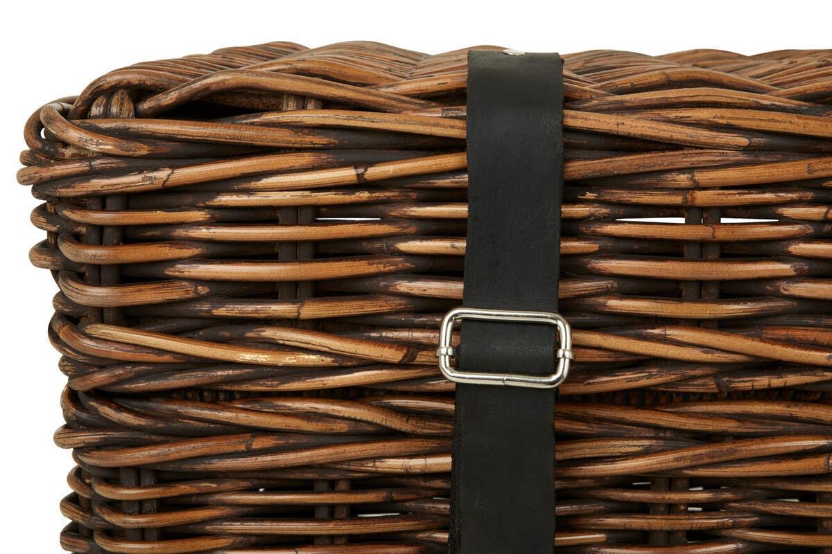 Close-up of wicker basket with black leather strap and silver buckle detail